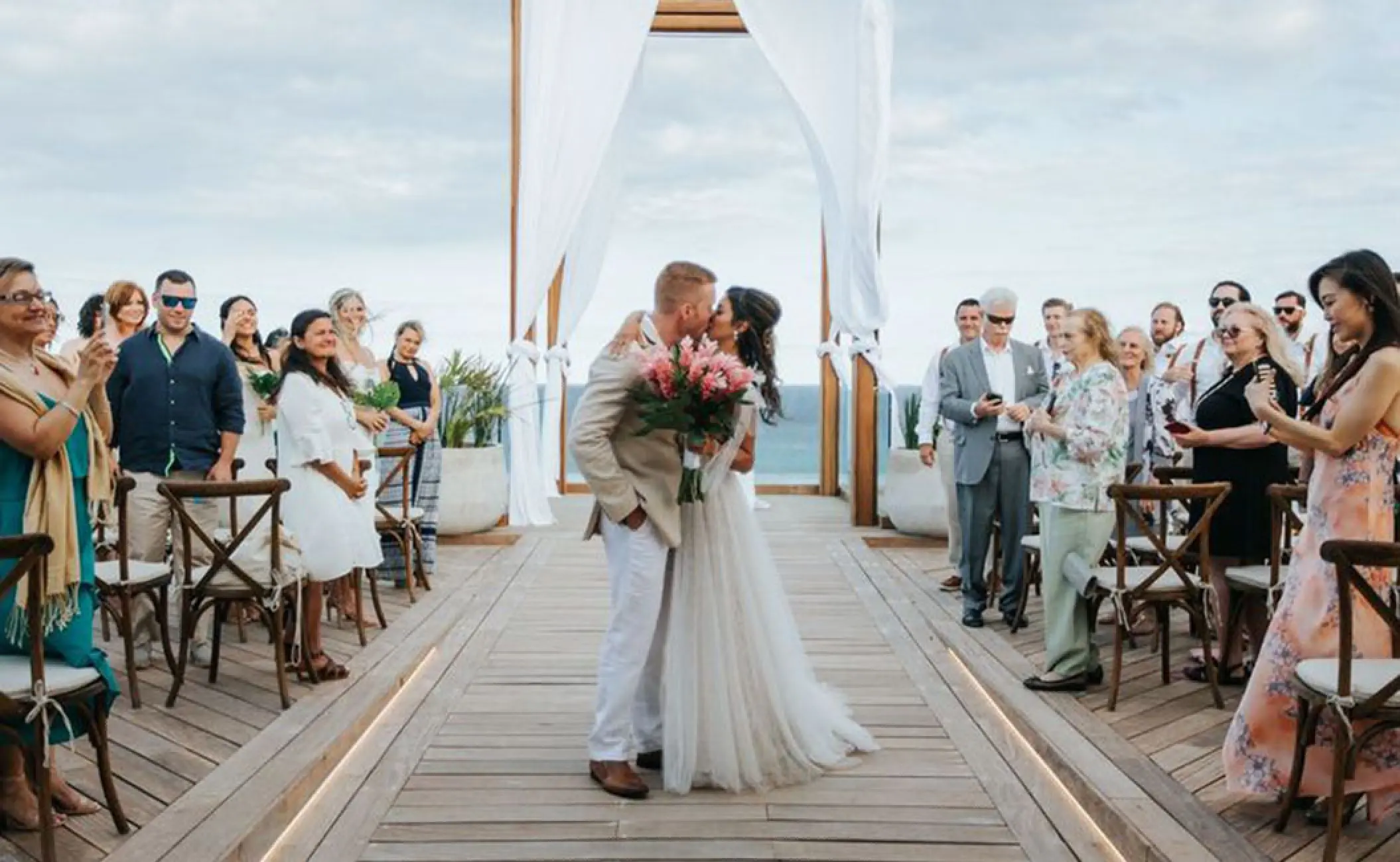 The couple kissing at the end of their wedding ceremony aisle at Secrets Moxche, Playa Del Carmen