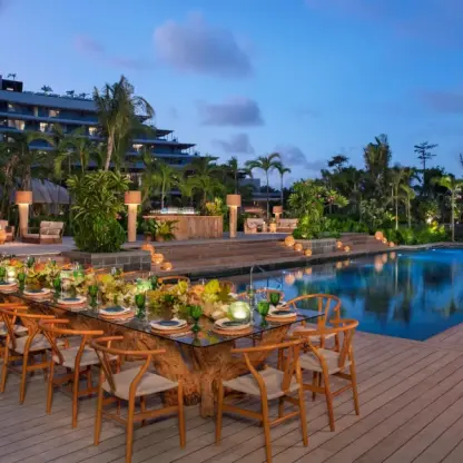 Pool deck wedding reception with a long wooden table at Secrets Moxche, Playa Del Carmen