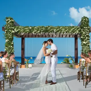 Terrace wedding ceremony under a floral pergola at Secrets Playa Mujeres, Cancun