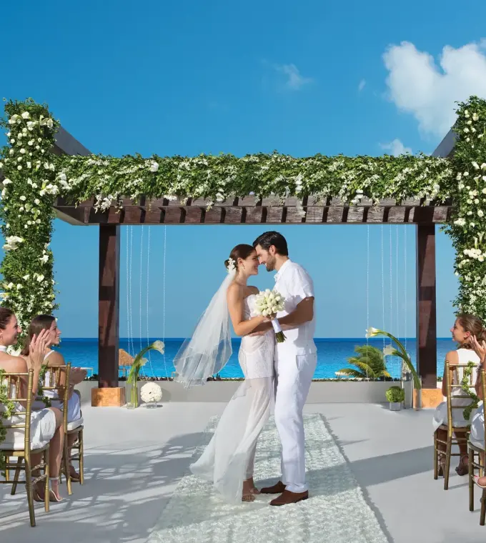 Terrace wedding ceremony under a floral pergola at Secrets Playa Mujeres, Cancun