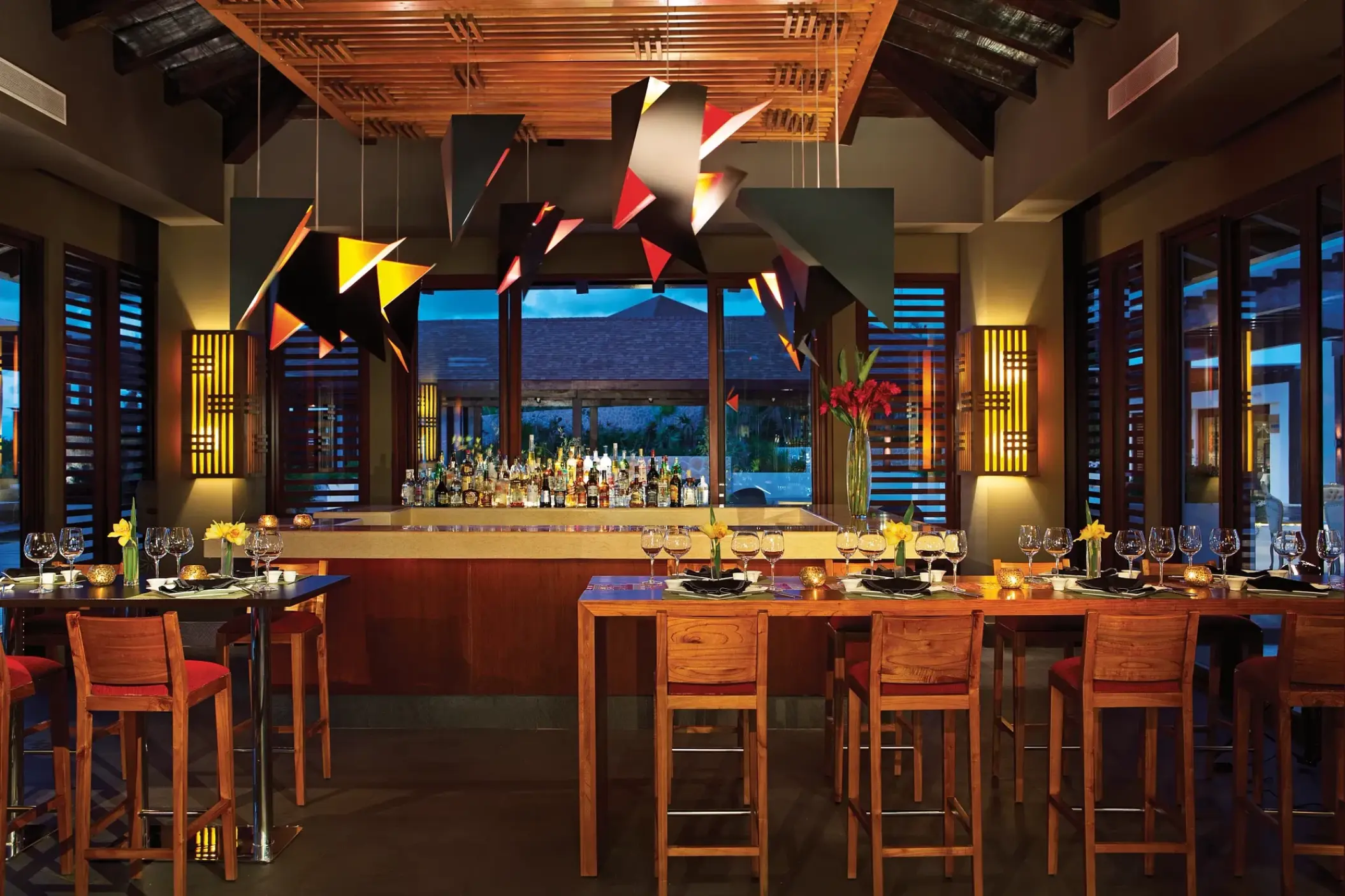 Himitsu sushi bar with modern geometric lighting and wood seating at Secrets Playa Mujeres, Cancun