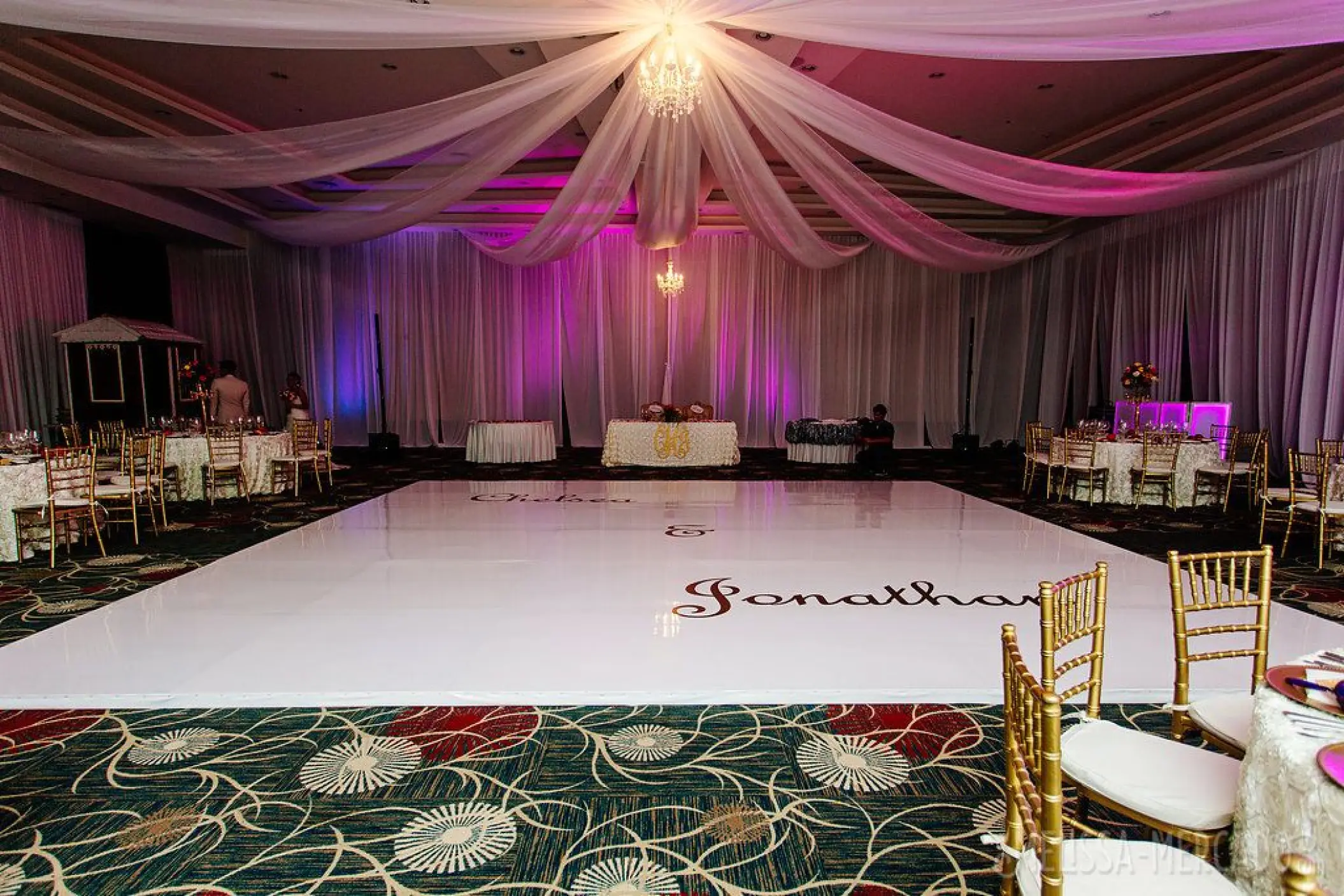 Indoor ballroom wedding reception with a white dance floor and fabric ceiling draping at Secrets Playa Mujeres, Cancun