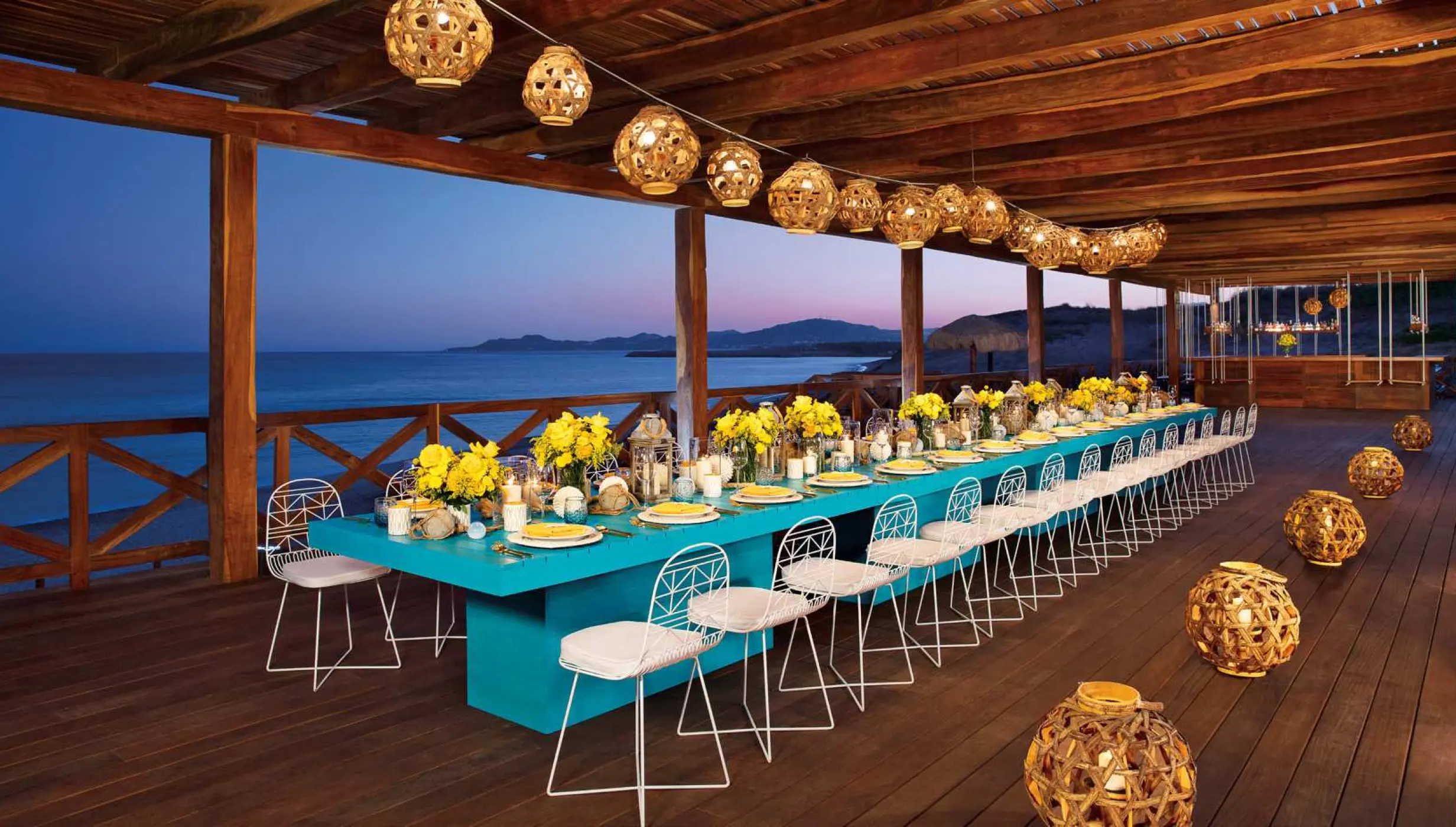Long banquet table with turquoise runner and yellow flowers at Secrets Puerto Los Cabos, Cabo San Lucas