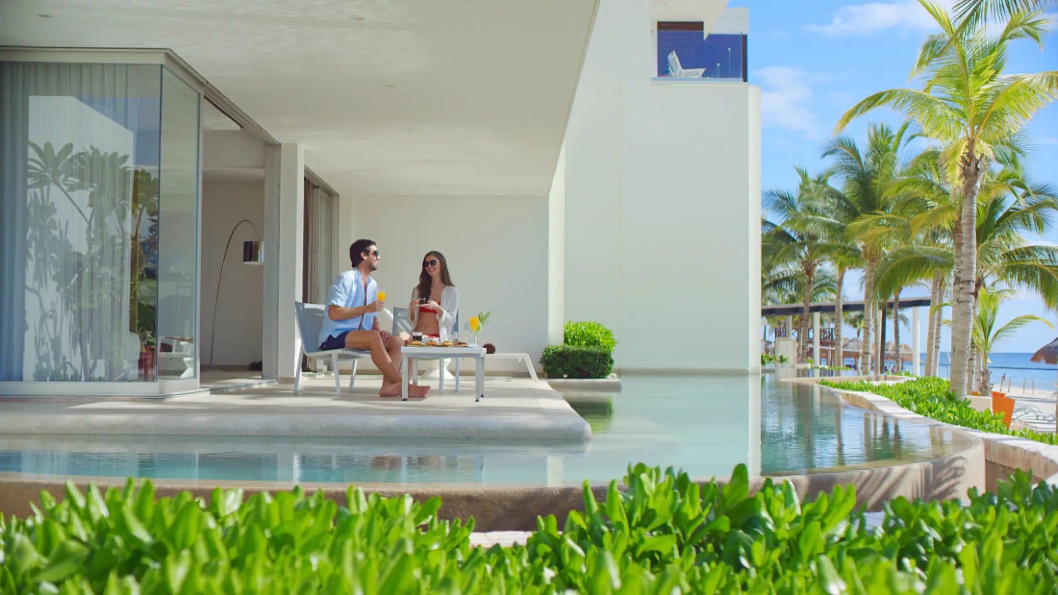 Couple sitting on a private terrace with a swim-out pool at Secrets Riviera Cancun, Riviera Maya