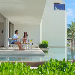 Couple sitting on a private terrace with a swim-out pool at Secrets Riviera Cancun, Riviera Maya