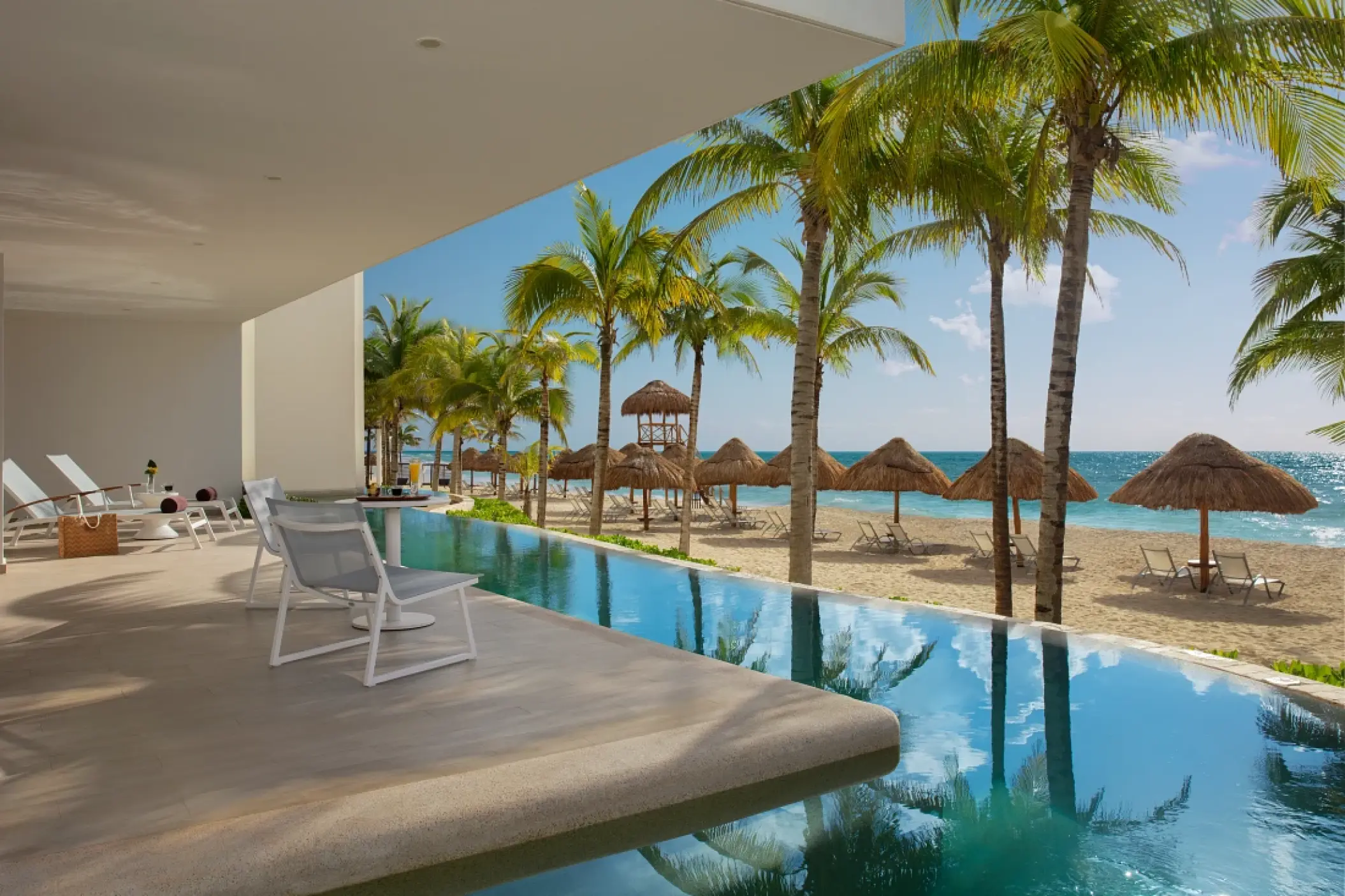 Secrets Riviera Cancun swim-out suite terrace overlooking the beach and palm trees, Riviera Maya