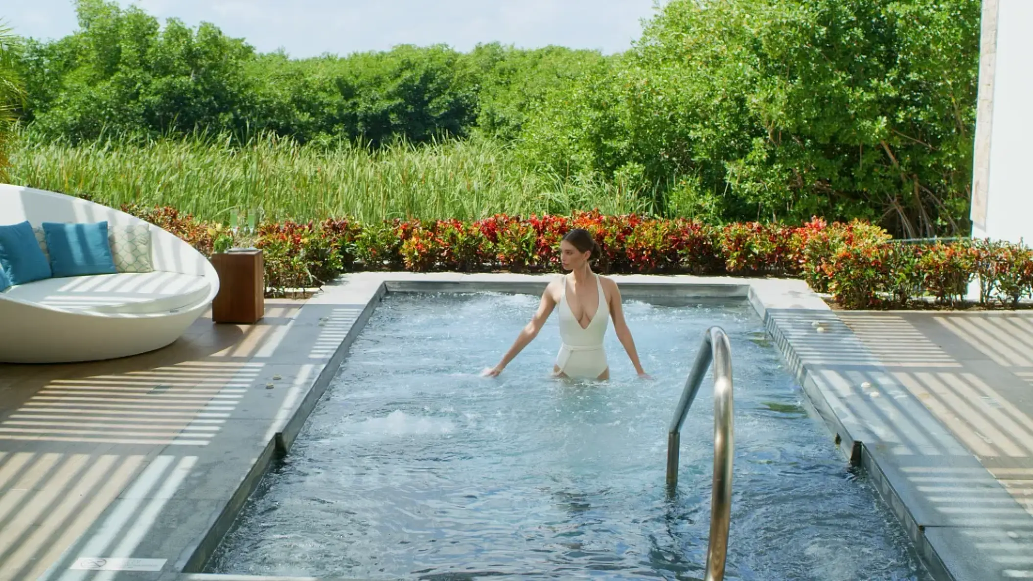 Woman in a white swimsuit wading in a private plunge pool at Secrets Riviera Cancun, Riviera Maya