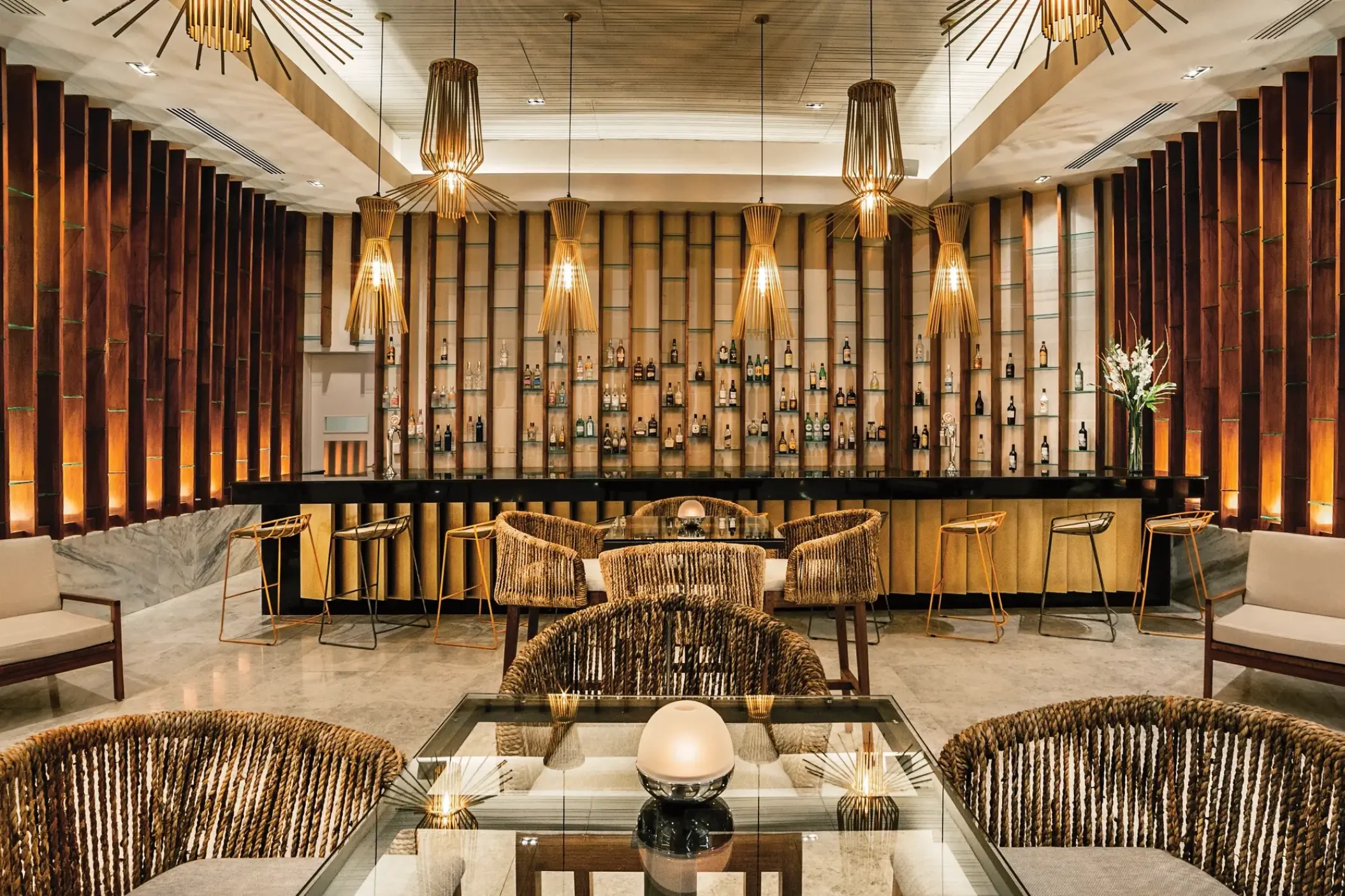 Rendezvous bar with woven pendant lights and wood paneling at Secrets Royal Beach, Punta Cana