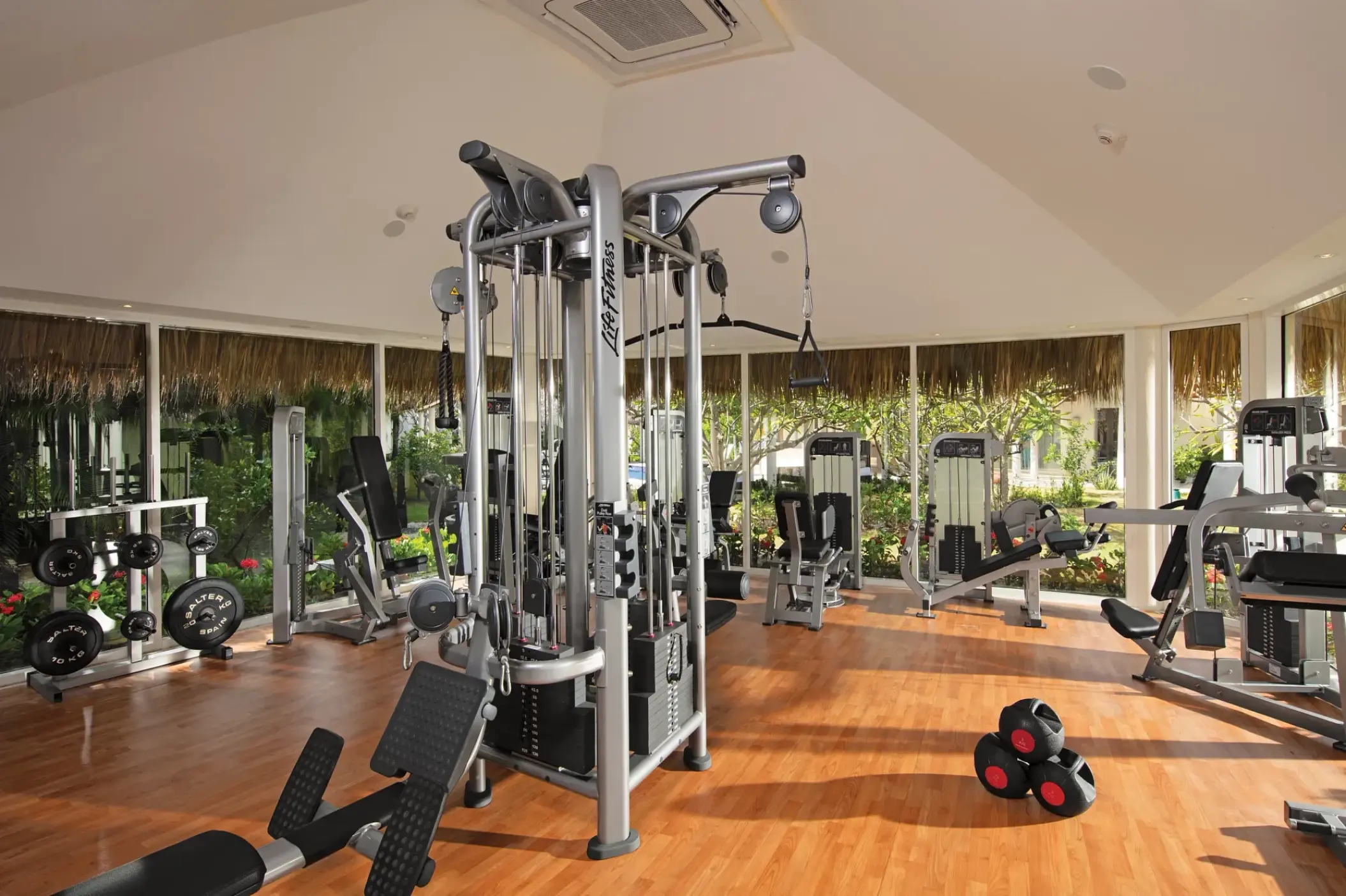 Fitness center with weight machines and floor-to-ceiling windows at Secrets Royal Beach, Punta Cana