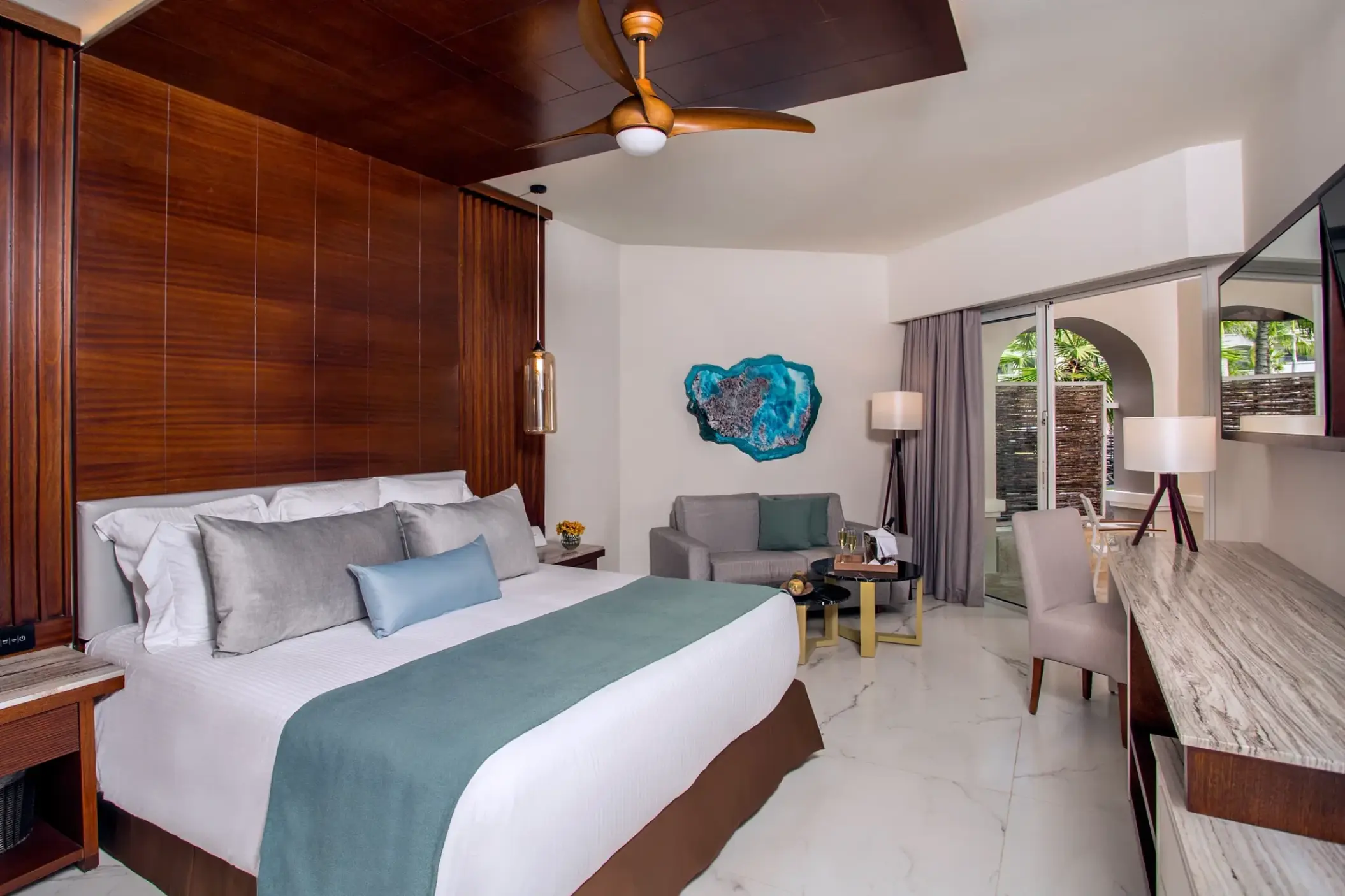 Junior suite with wood-paneled walls and blue accents at Secrets Royal Beach, Punta Cana
