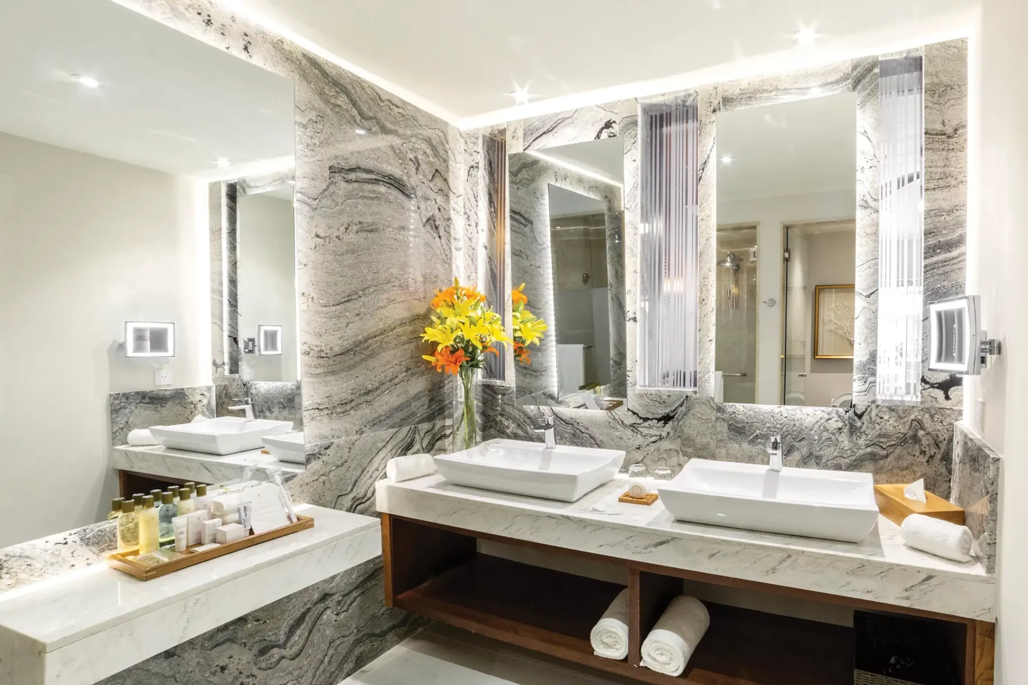Double vanity bathroom with marble walls and vessel sinks at Secrets Royal Beach, Punta Cana