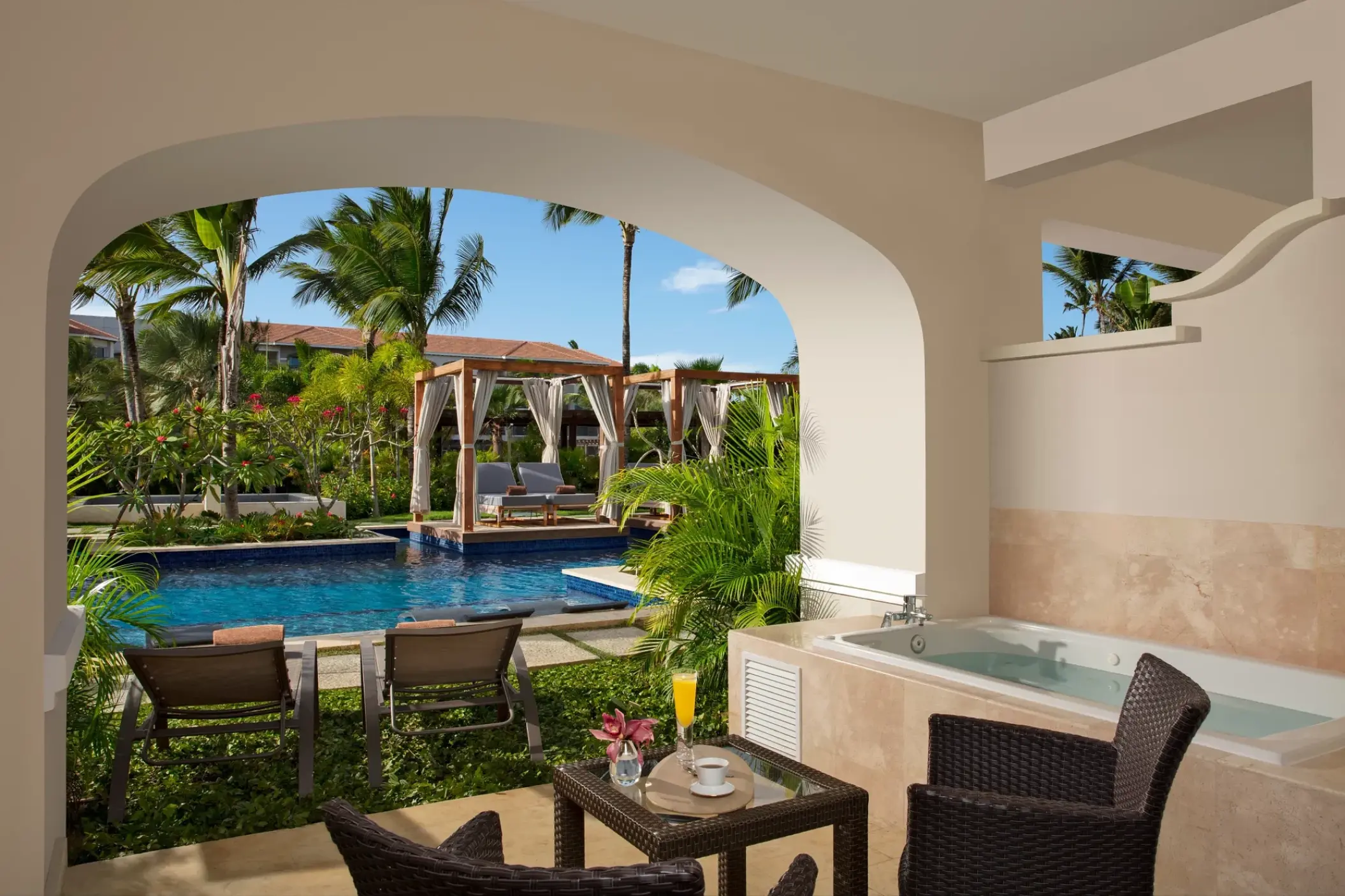 Junior Suite swim-out terrace with hot tub overlooking the pool at Secrets Royal Beach, Punta Cana