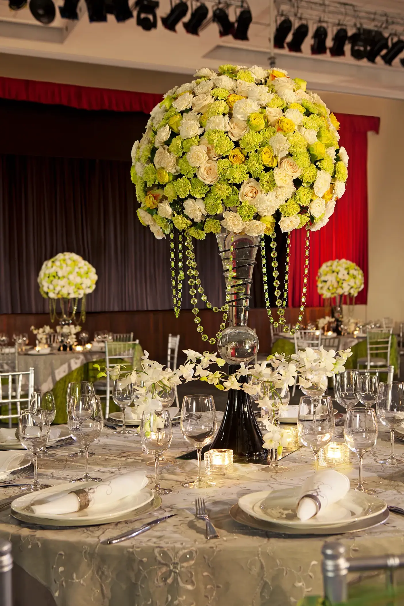 Green and white floral centerpiece at a ballroom wedding reception in Secrets Royal Beach, Punta Cana
