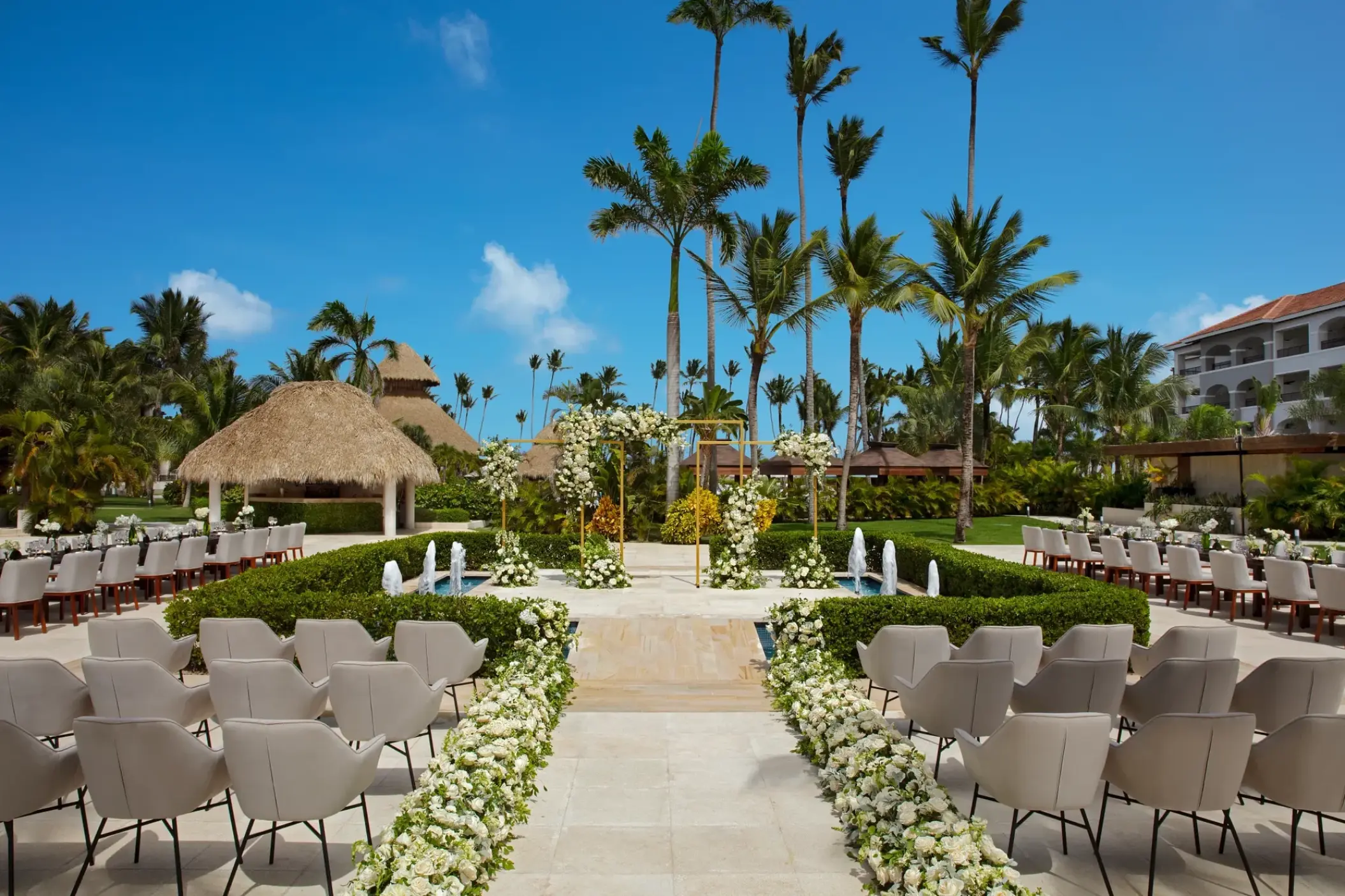 Terrace wedding ceremony with white floral aisle and fountain at Secrets Royal Beach, Punta Cana