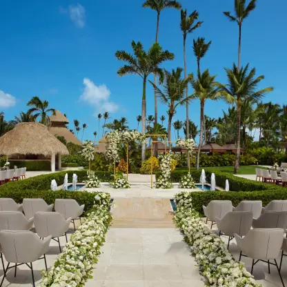 Terrace wedding ceremony with white floral aisle and fountain at Secrets Royal Beach, Punta Cana