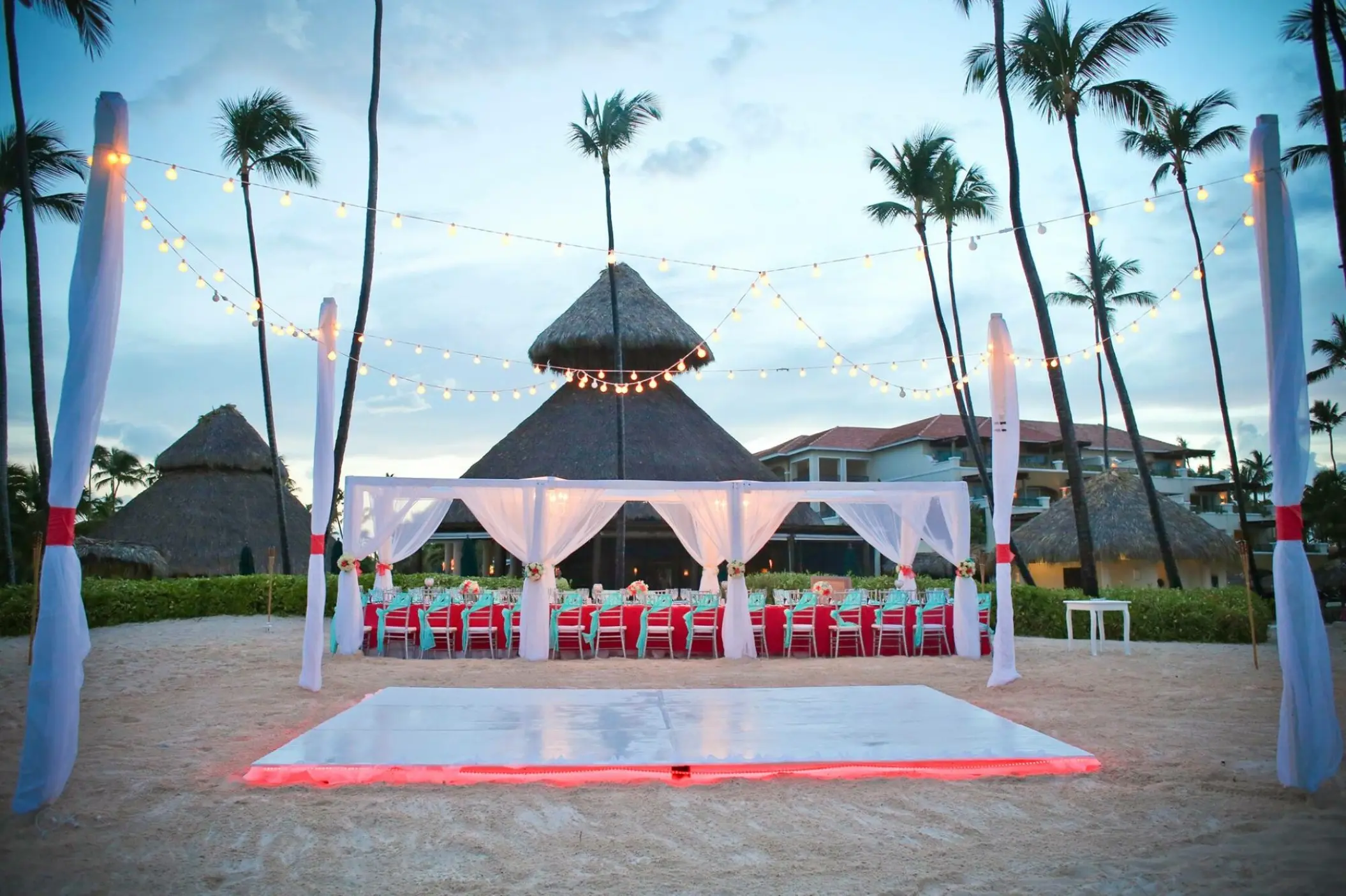 Beachfront wedding reception with dance floor and string lights at Secrets Royal Beach, Punta Cana