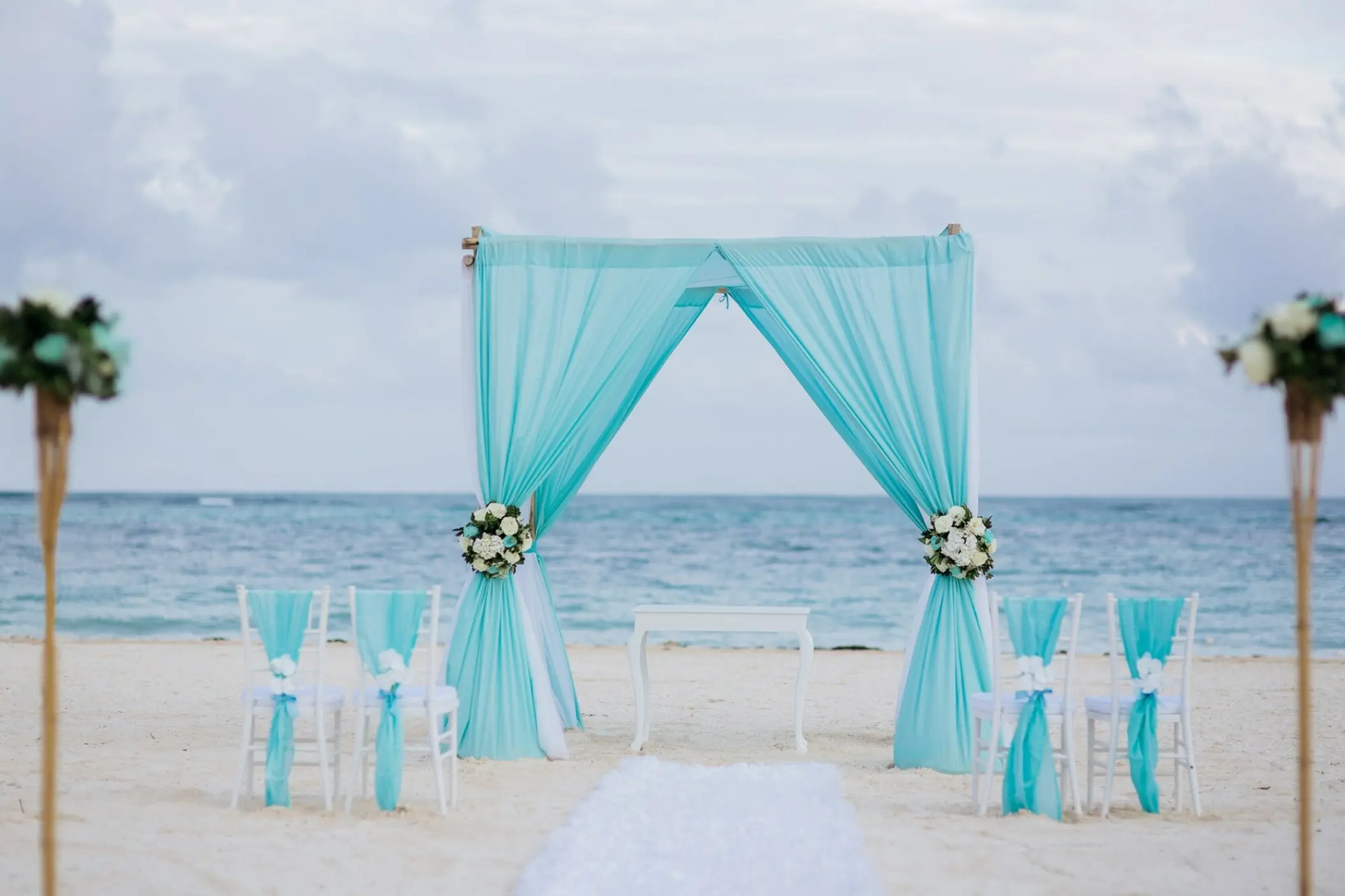 Beachfront wedding ceremony setup with turquoise drapery at Secrets Royal Beach, Punta Cana