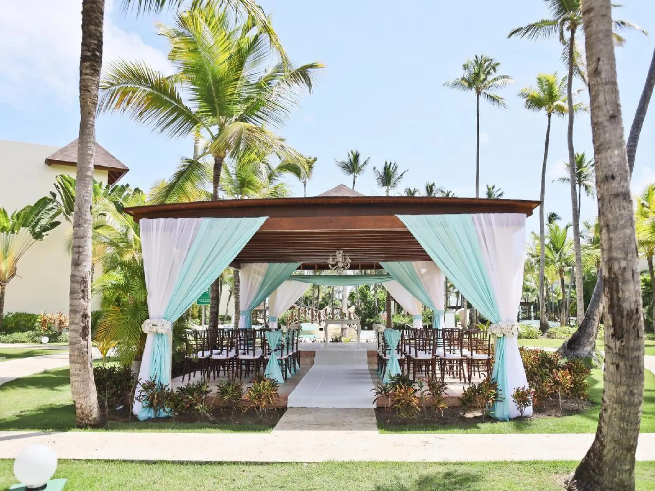 Garden wedding ceremony gazebo with teal and white draping at Secrets Royal Beach, Punta Cana