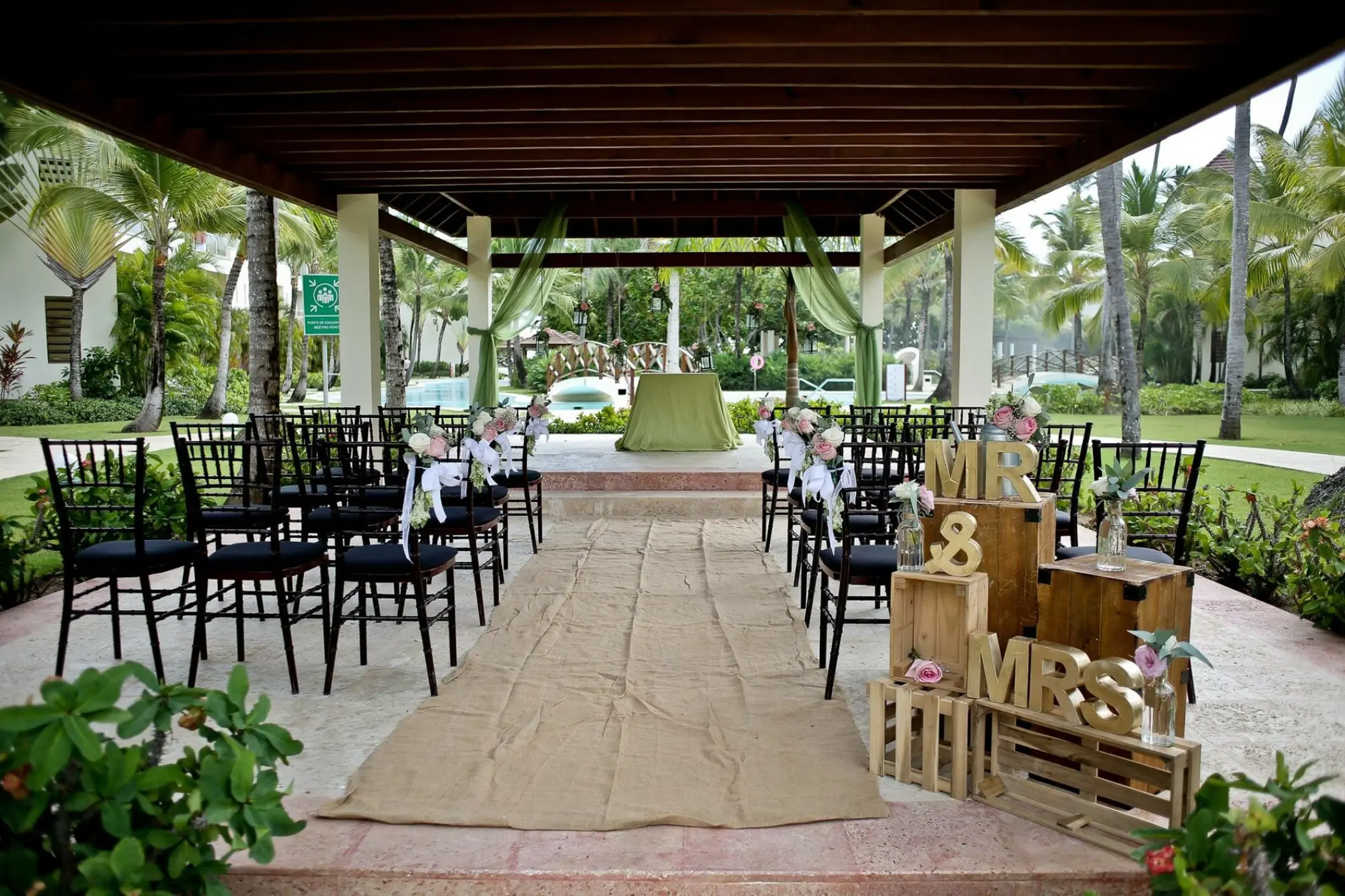 Garden wedding ceremony setup at Secrets Royal Beach, Punta Cana with a burlap aisle runner and Mr & Mrs decor