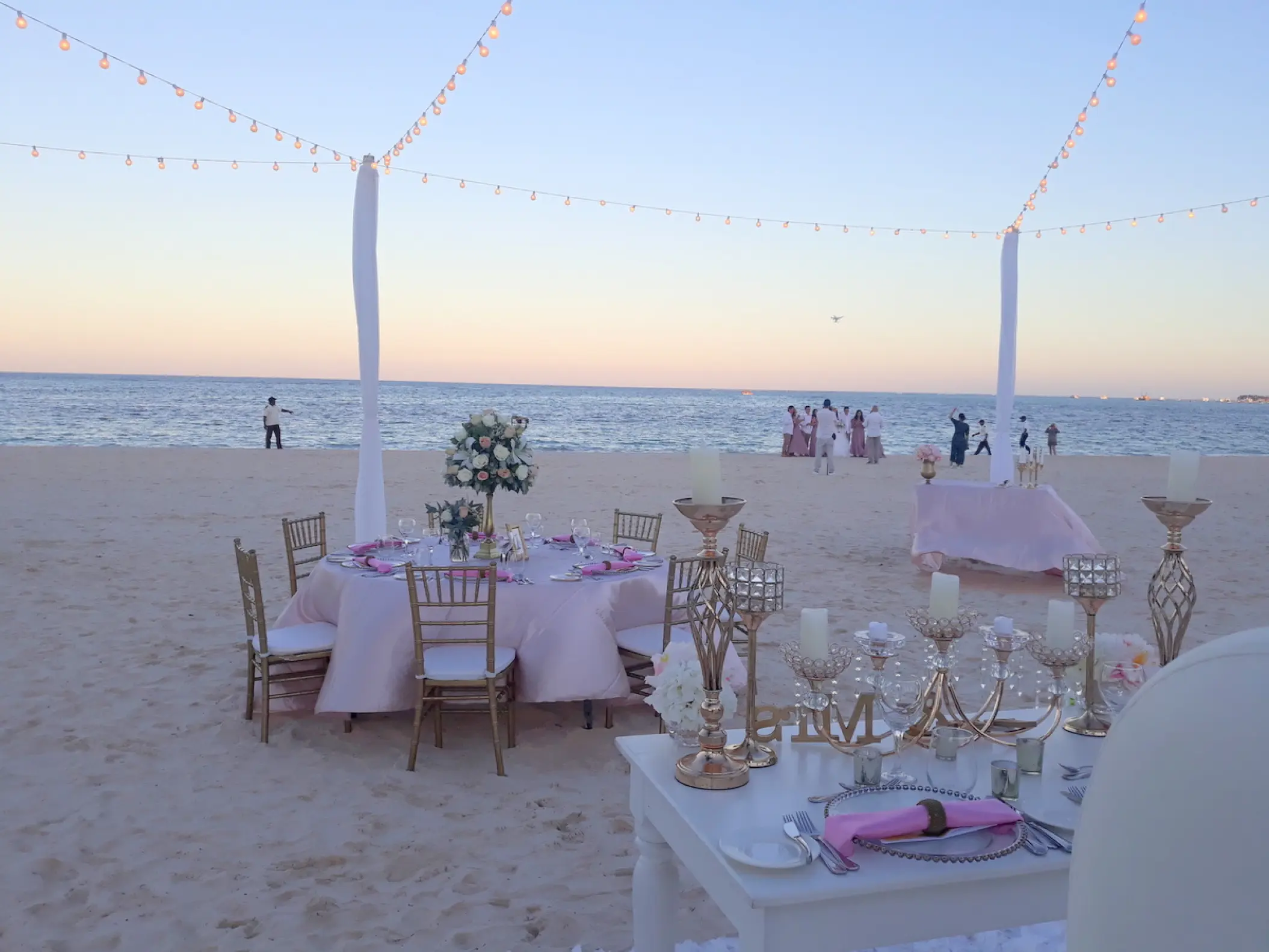 Beachfront wedding reception with pink linens and gold accents at Secrets Royal Beach, Punta Cana