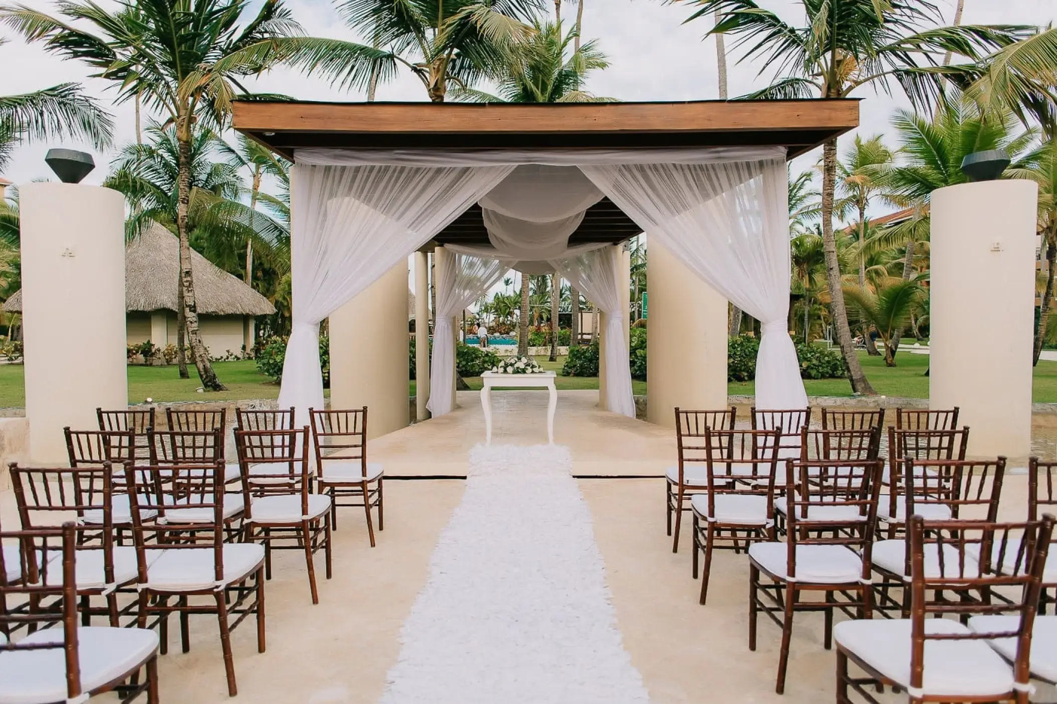 Draped wedding gazebo with wooden chairs at Secrets Royal Beach, Punta Cana