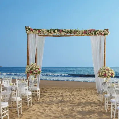 Beachfront wedding ceremony with a floral wooden arch at Secrets Vallarta Bay, Puerto Vallarta