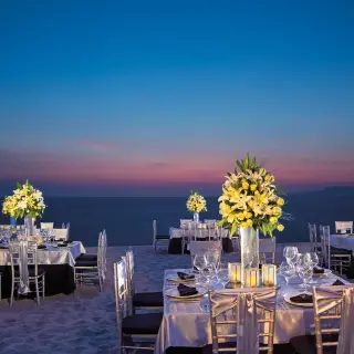 Beachfront wedding reception tables with floral centerpieces at sunset at Secrets Vallarta Bay, Puerto Vallarta