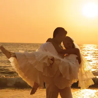 Groom carrying his bride on the beach at sunset at Secrets Vallarta Bay, Puerto Vallarta