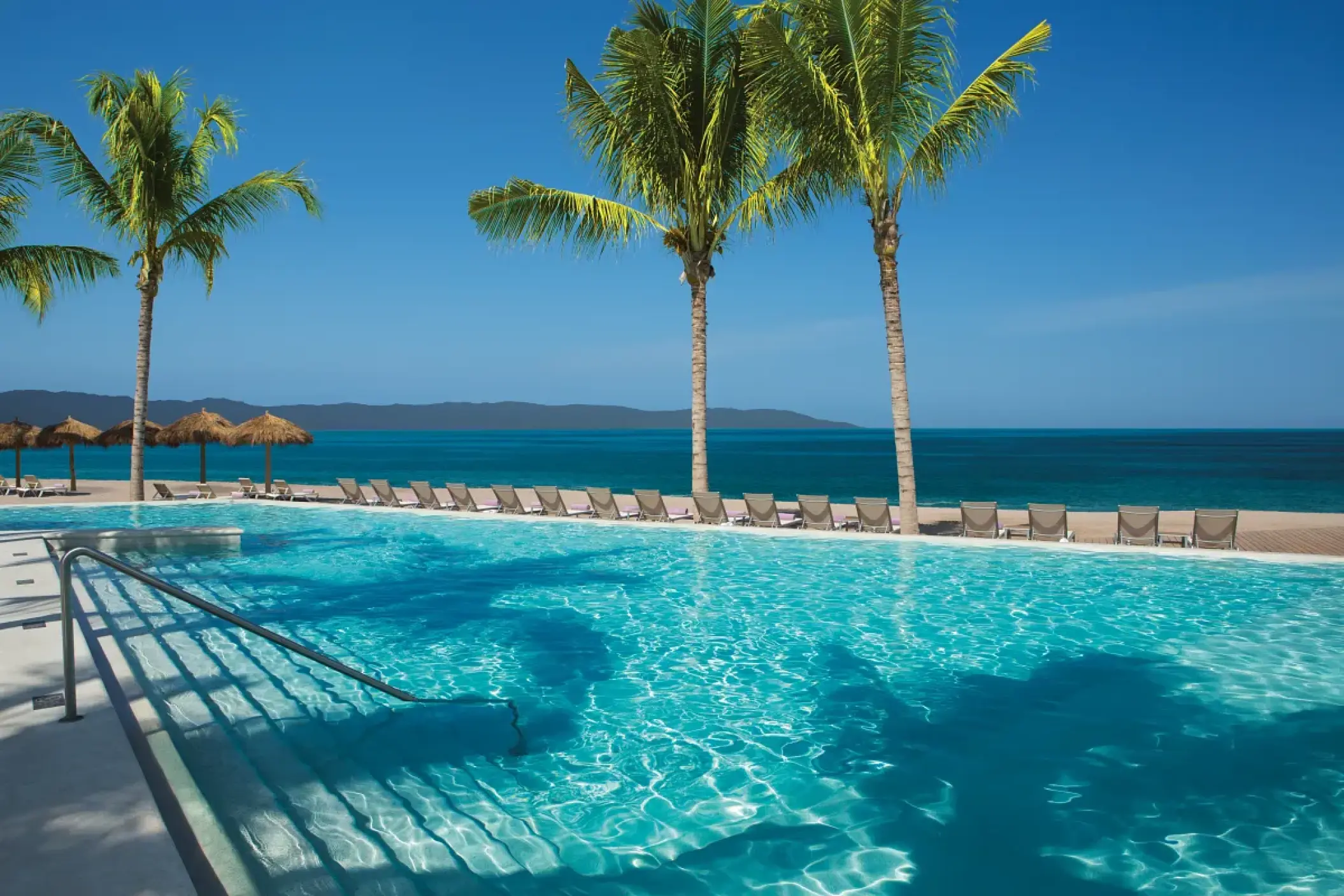 Secrets Vallarta Bay infinity pool with palm trees overlooking the ocean, Puerto Vallarta