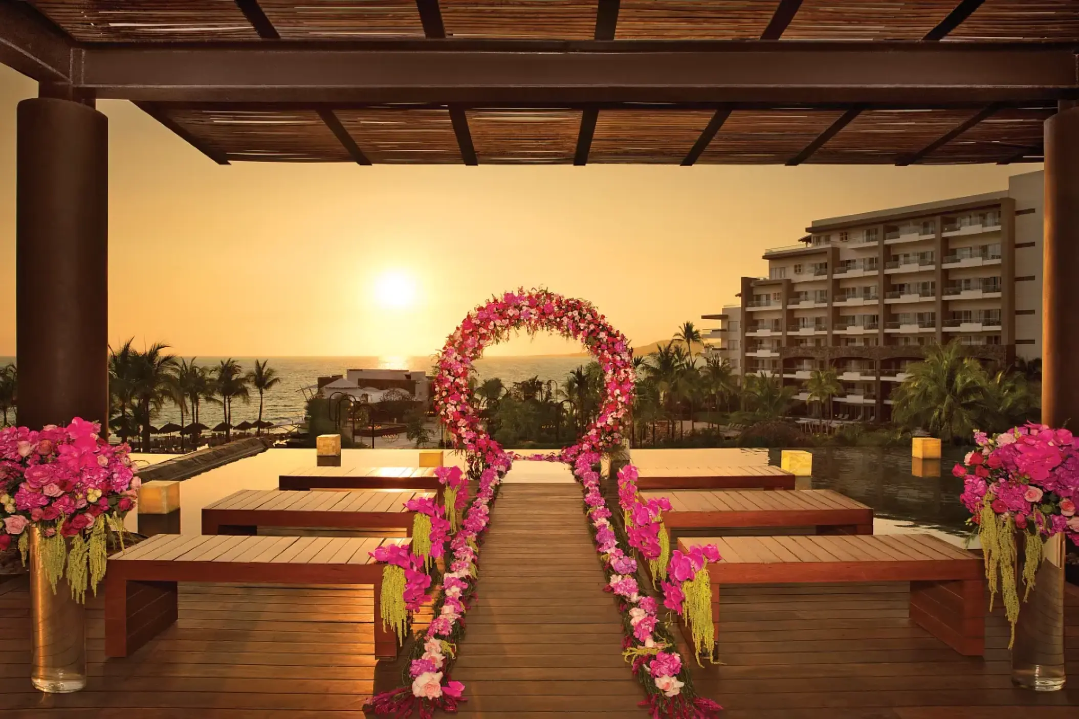Sunset wedding ceremony setup with pink floral arch at Secrets Vallarta Bay, Puerto Vallarta