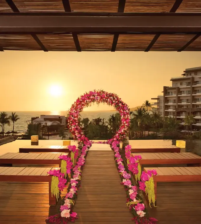 Sunset wedding ceremony setup with pink floral arch at Secrets Vallarta Bay, Puerto Vallarta