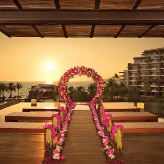 Sunset wedding ceremony setup with pink floral arch at Secrets Vallarta Bay, Puerto Vallarta