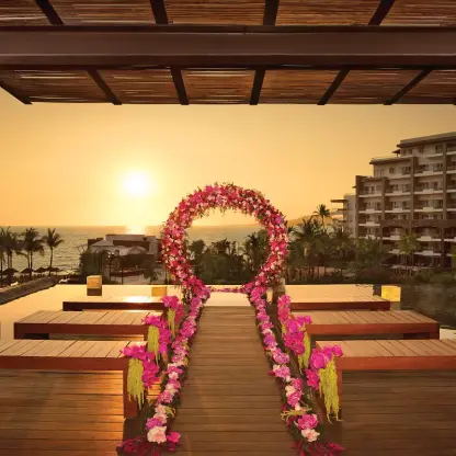 Sunset wedding ceremony setup with pink floral arch at Secrets Vallarta Bay, Puerto Vallarta