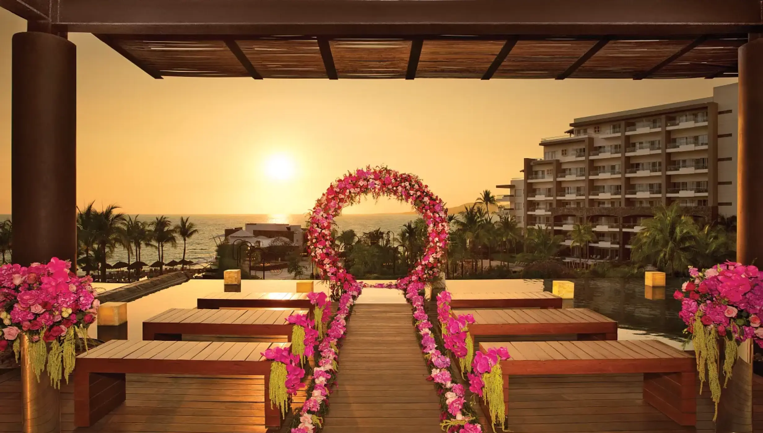 Sunset wedding ceremony setup with pink floral arch at Secrets Vallarta Bay, Puerto Vallarta