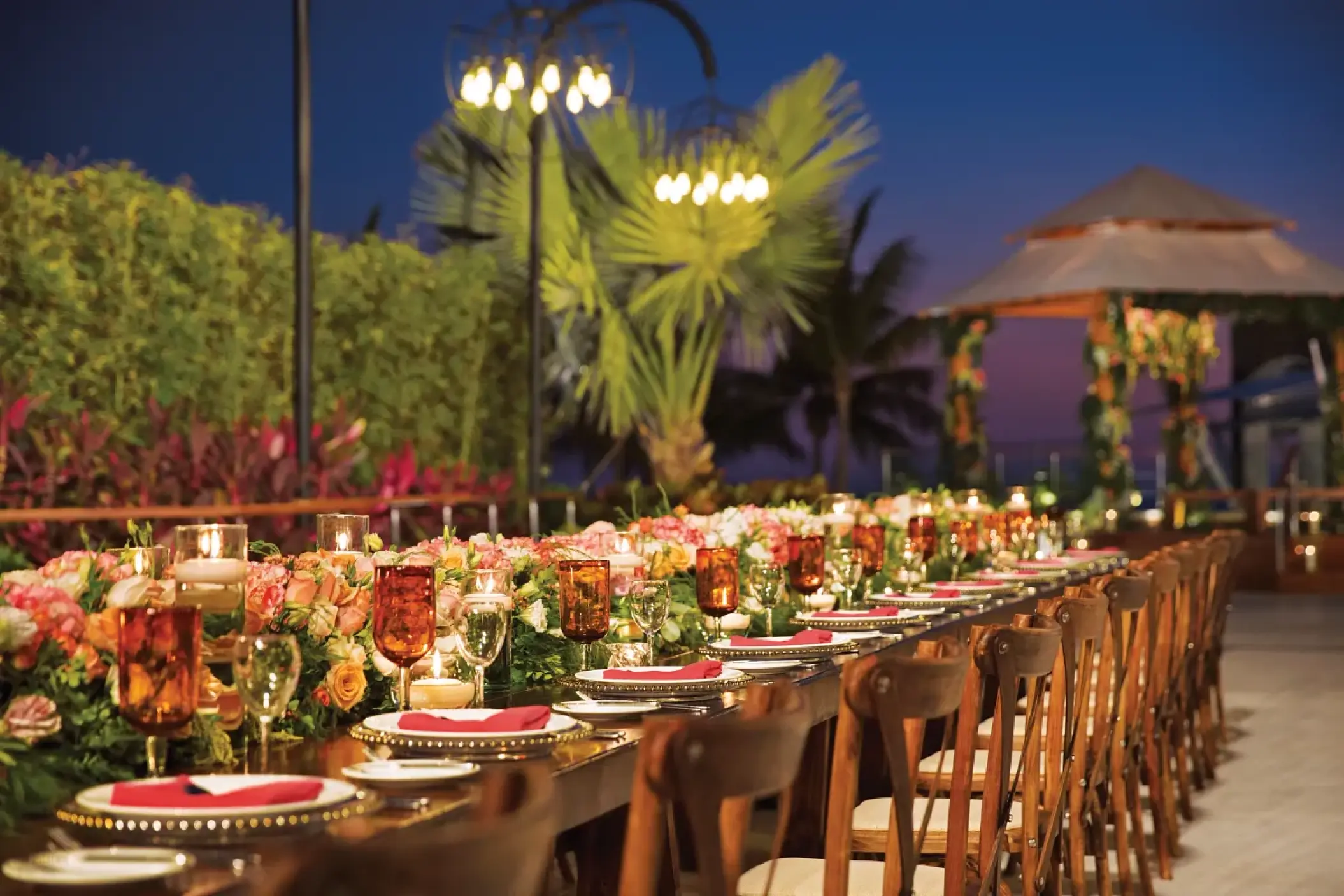 Terrace wedding reception with floral centerpieces and candles at Secrets Vallarta Bay, Puerto Vallarta