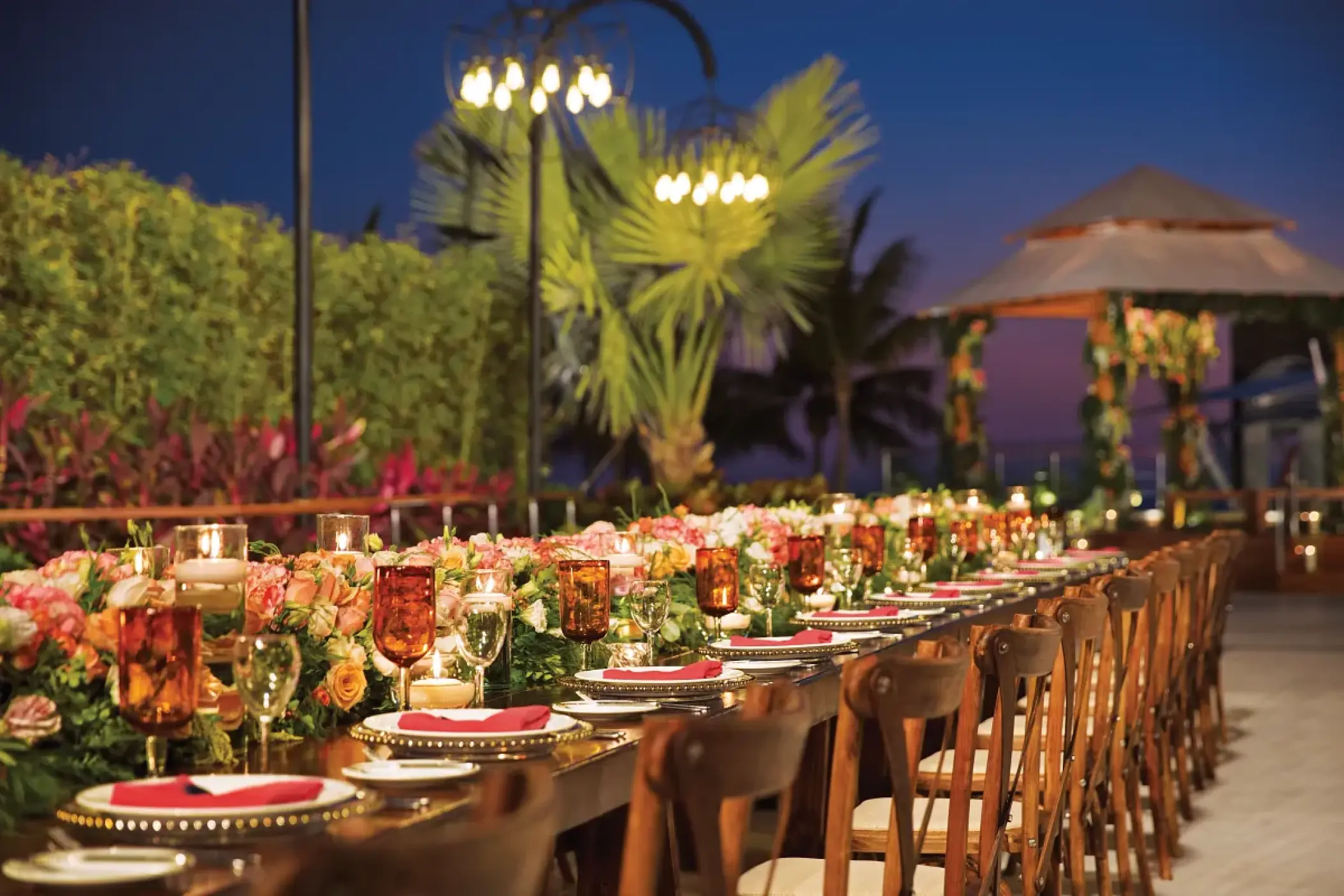 Terrace wedding reception with floral centerpieces and candles at Secrets Vallarta Bay, Puerto Vallarta
