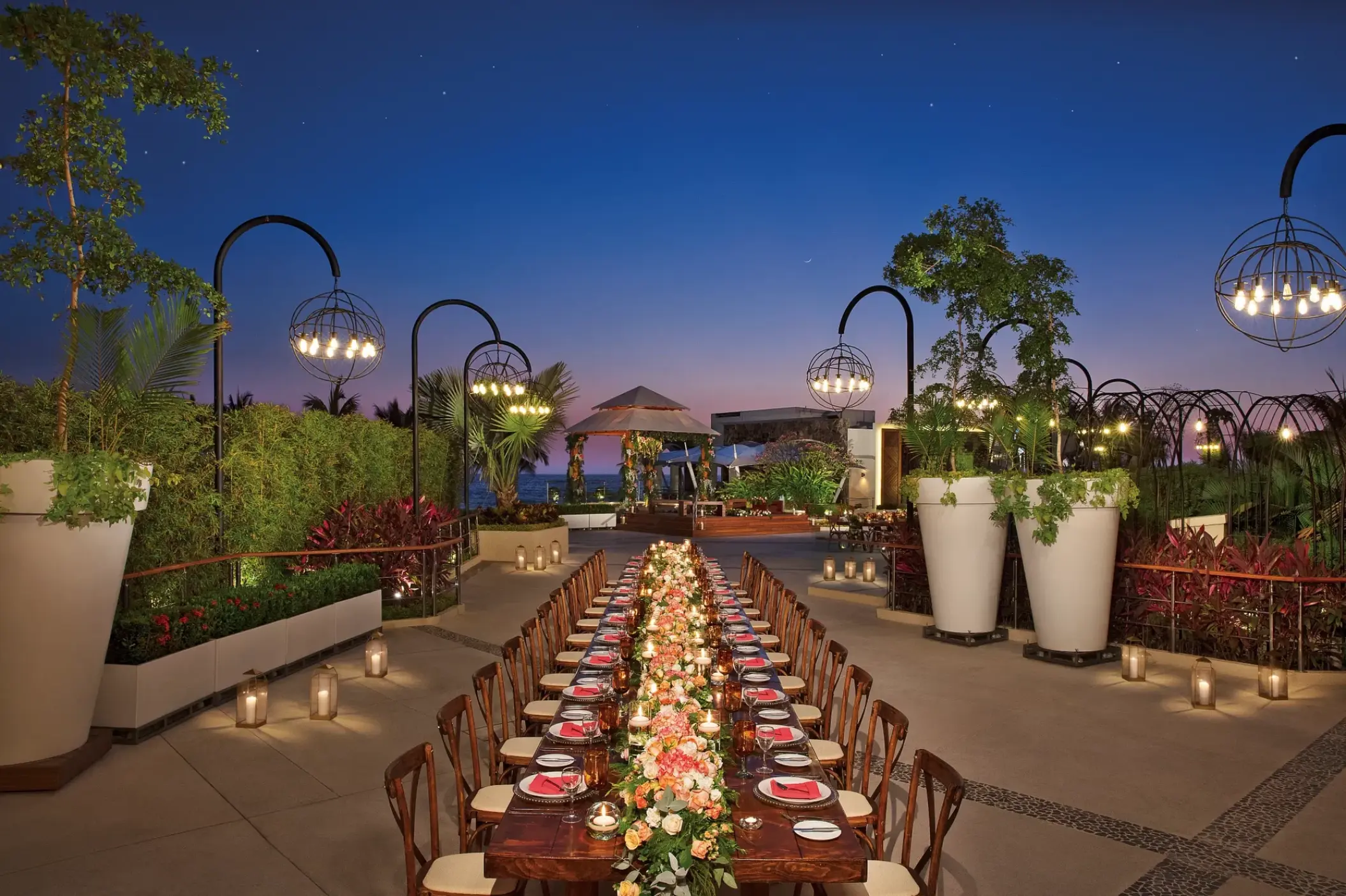 Outdoor wedding reception setup with a long table at night at Secrets Vallarta Bay, Puerto Vallarta