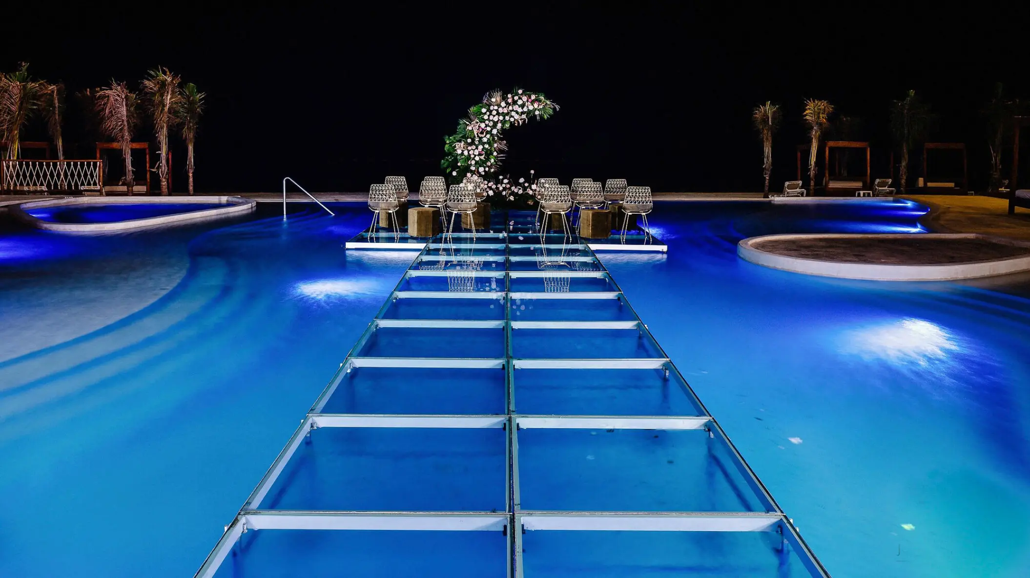 Pool aisle and wedding ceremony setup at night at Sensira Riviera Maya