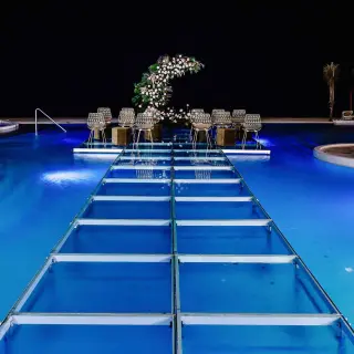 Pool aisle and wedding ceremony setup at night at Sensira Riviera Maya