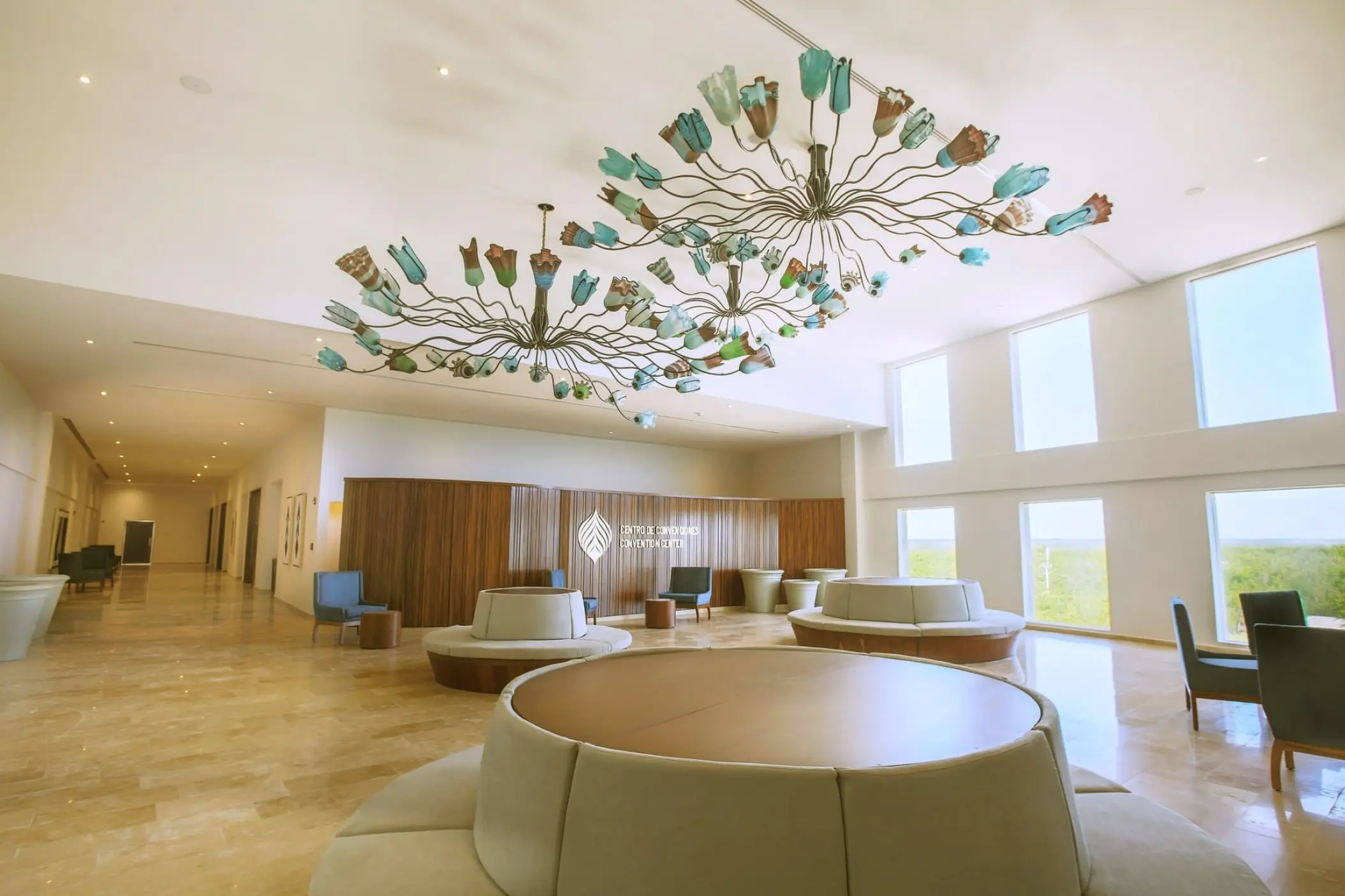 Convention center lobby with modern chandeliers and circular seating at Sensira Resort, Riviera Maya