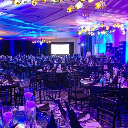 Indoor wedding reception with purple lighting and round tables at Sensira Resort, Riviera Maya