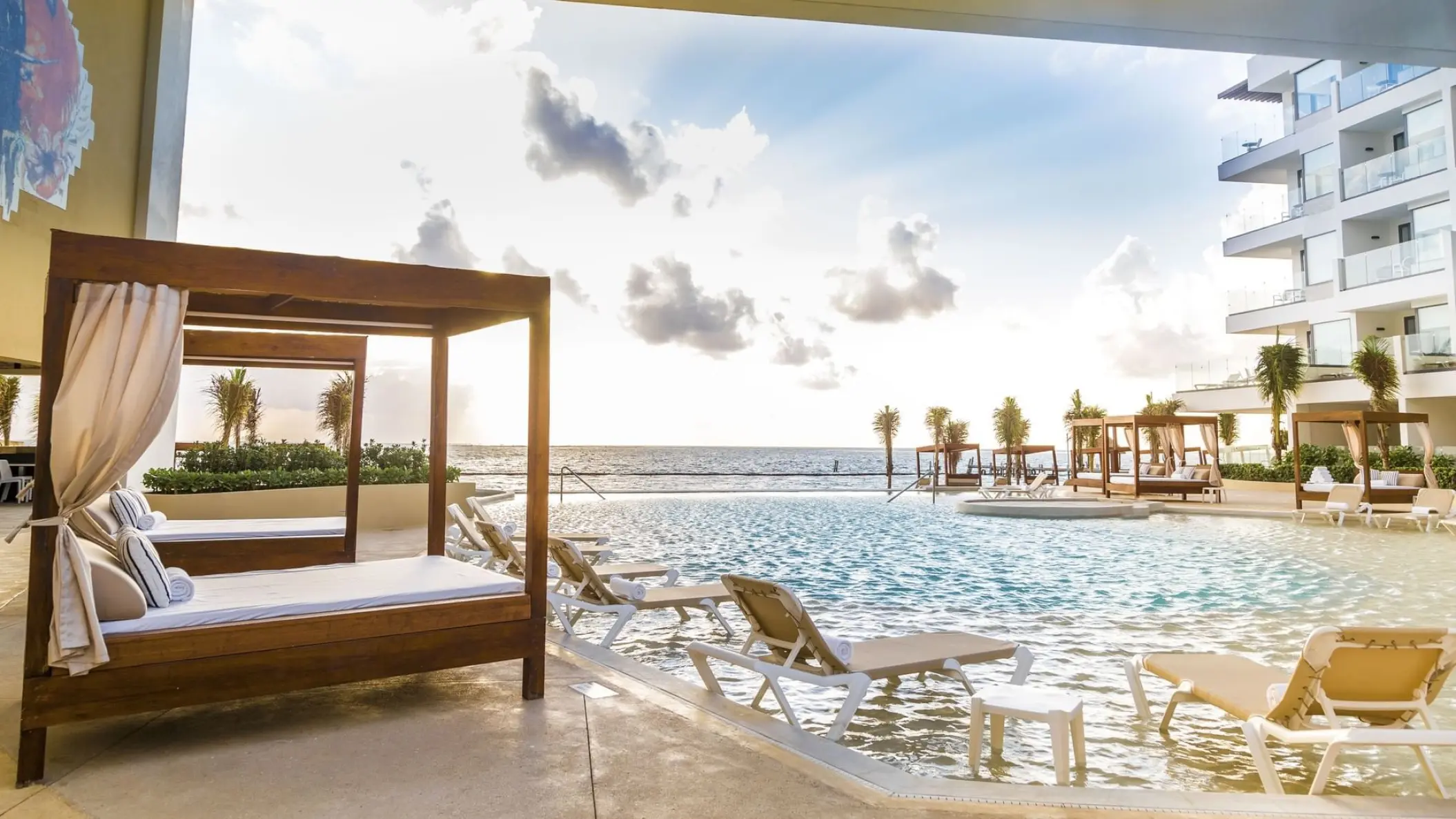 Sensira Riviera Maya outdoor pool with daybeds and lounge chairs overlooking the ocean, Riviera Maya