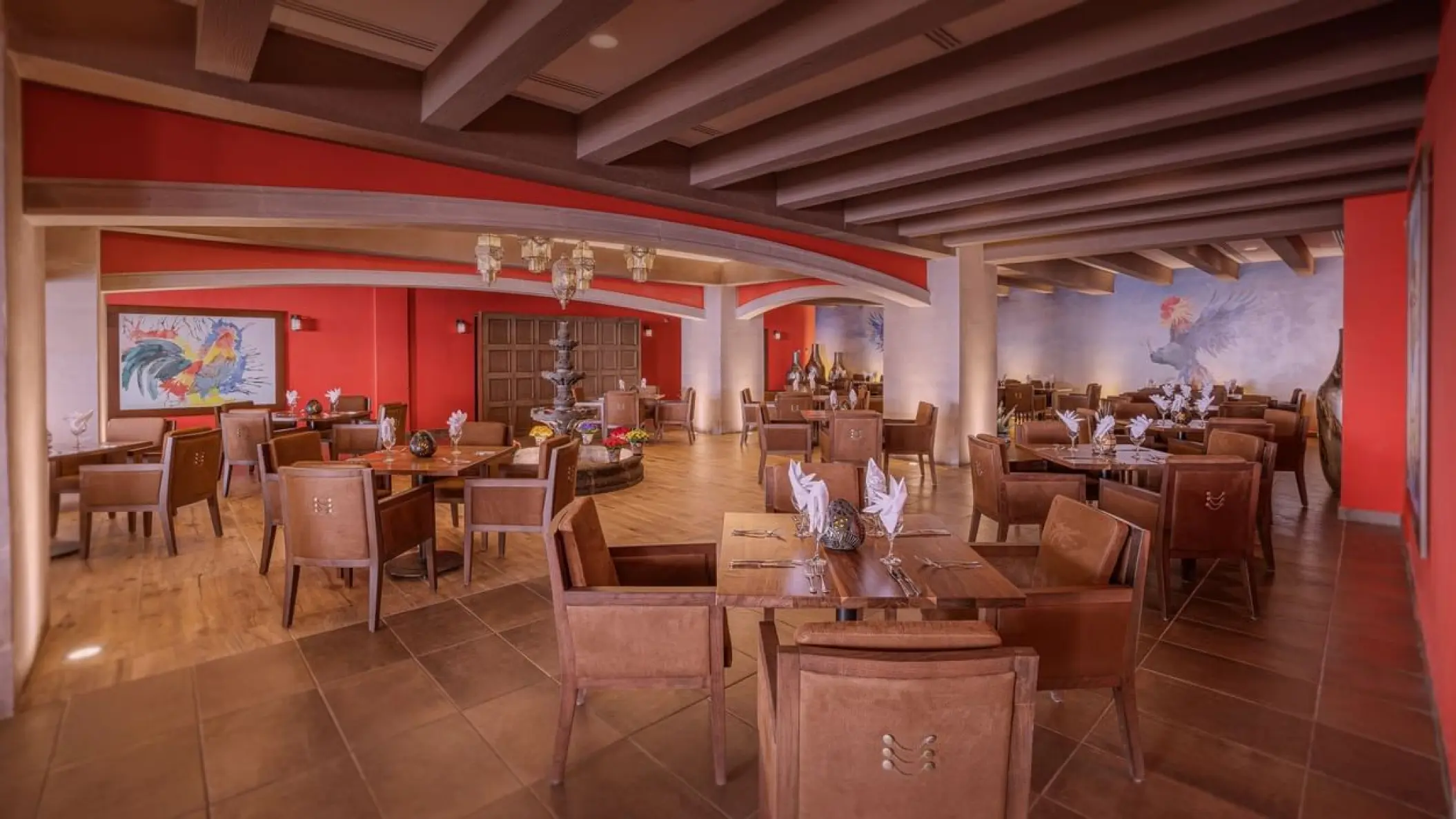 La Finca de Ana restaurant dining room with red walls and wooden tables at Sensira Resort, Riviera Maya