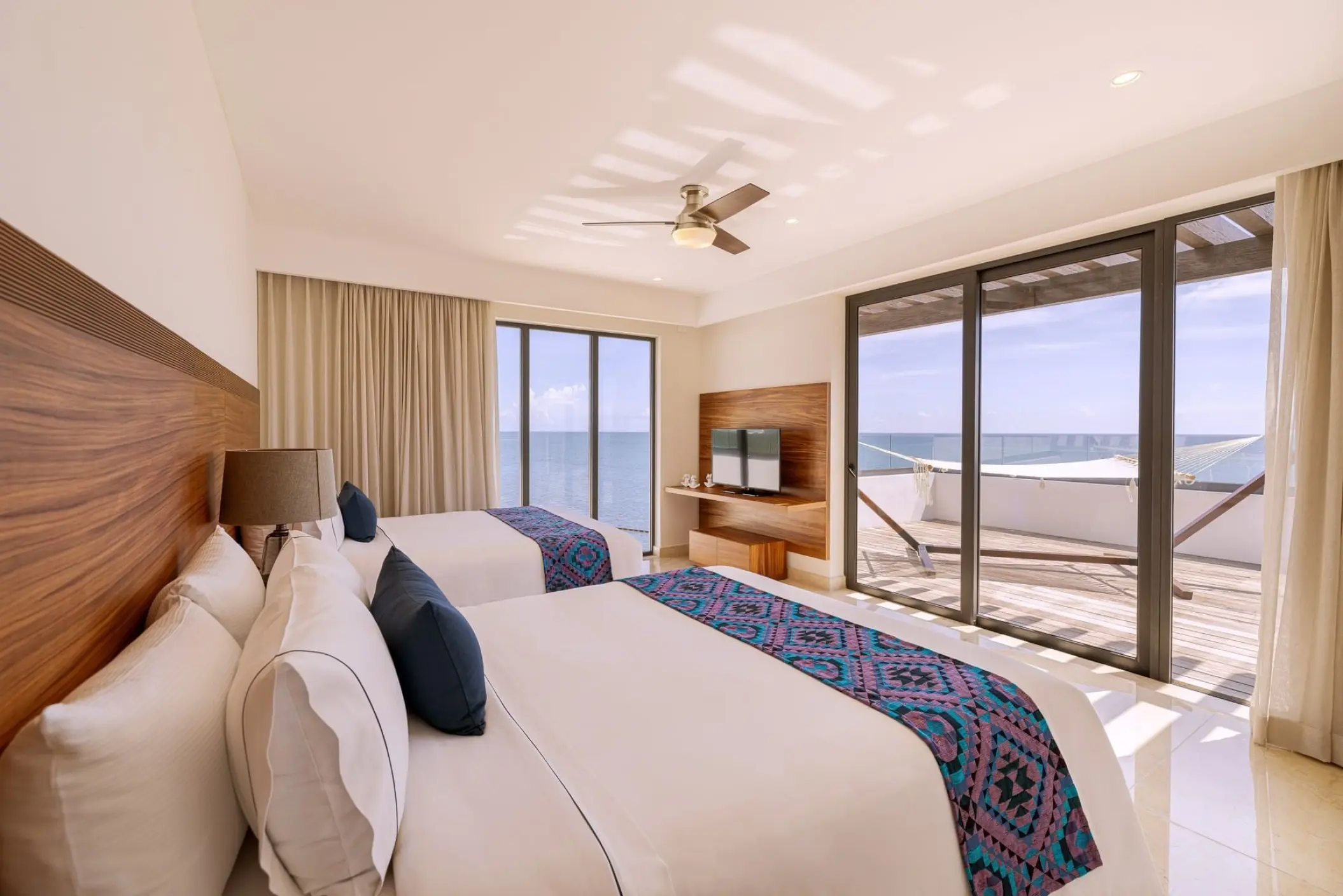 Diamond Suite with two beds and an ocean-view balcony at Sensira Riviera Maya