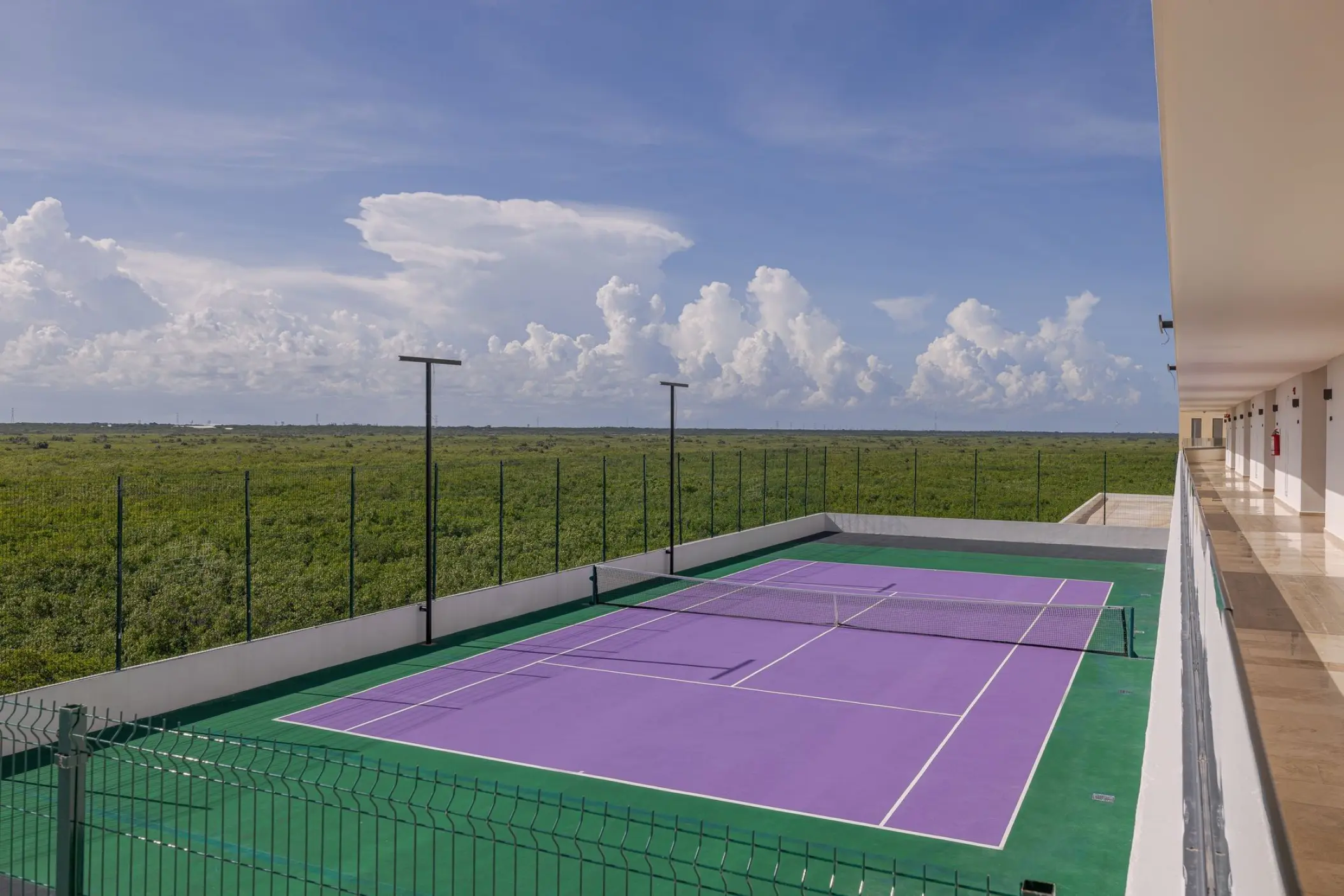 Purple and green rooftop tennis court at Sensira Resort, Riviera Maya