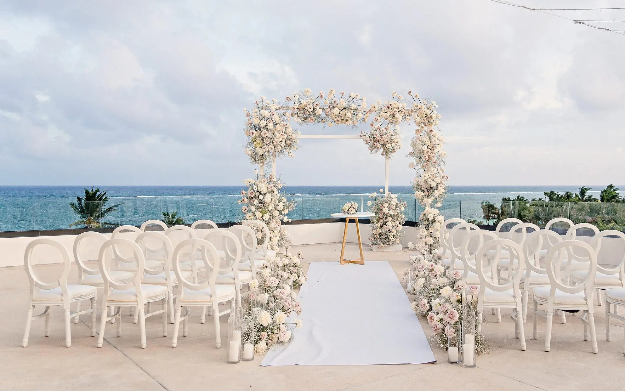Terrace wedding ceremony at Sensira Riviera Maya with white floral arch and ocean views