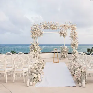Terrace wedding ceremony at Sensira Riviera Maya with white floral arch and ocean views