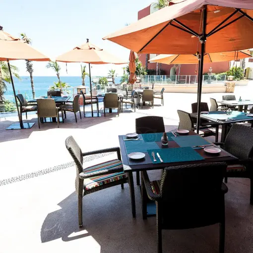 Outdoor restaurant terrace with orange umbrellas at Hyatt Vacation Club at Sirena del Mar, Cabo San Lucas