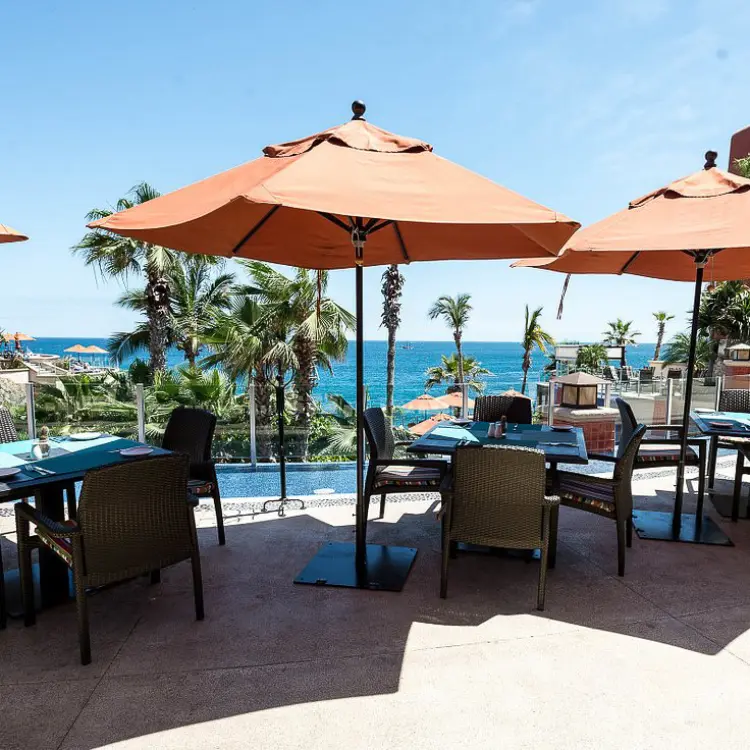 Outdoor restaurant terrace with orange umbrellas at Hyatt Sirena del Mar, Cabo San Lucas
