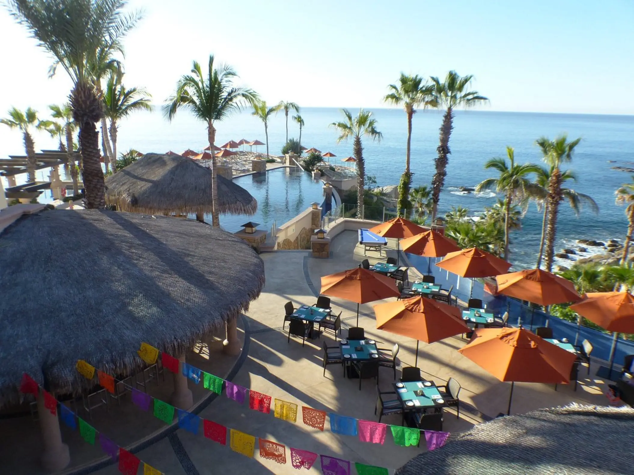 Outdoor terrace with orange umbrellas and palapa bar at Hyatt Vacation Club at Sirena del Mar, Cabo San Lucas